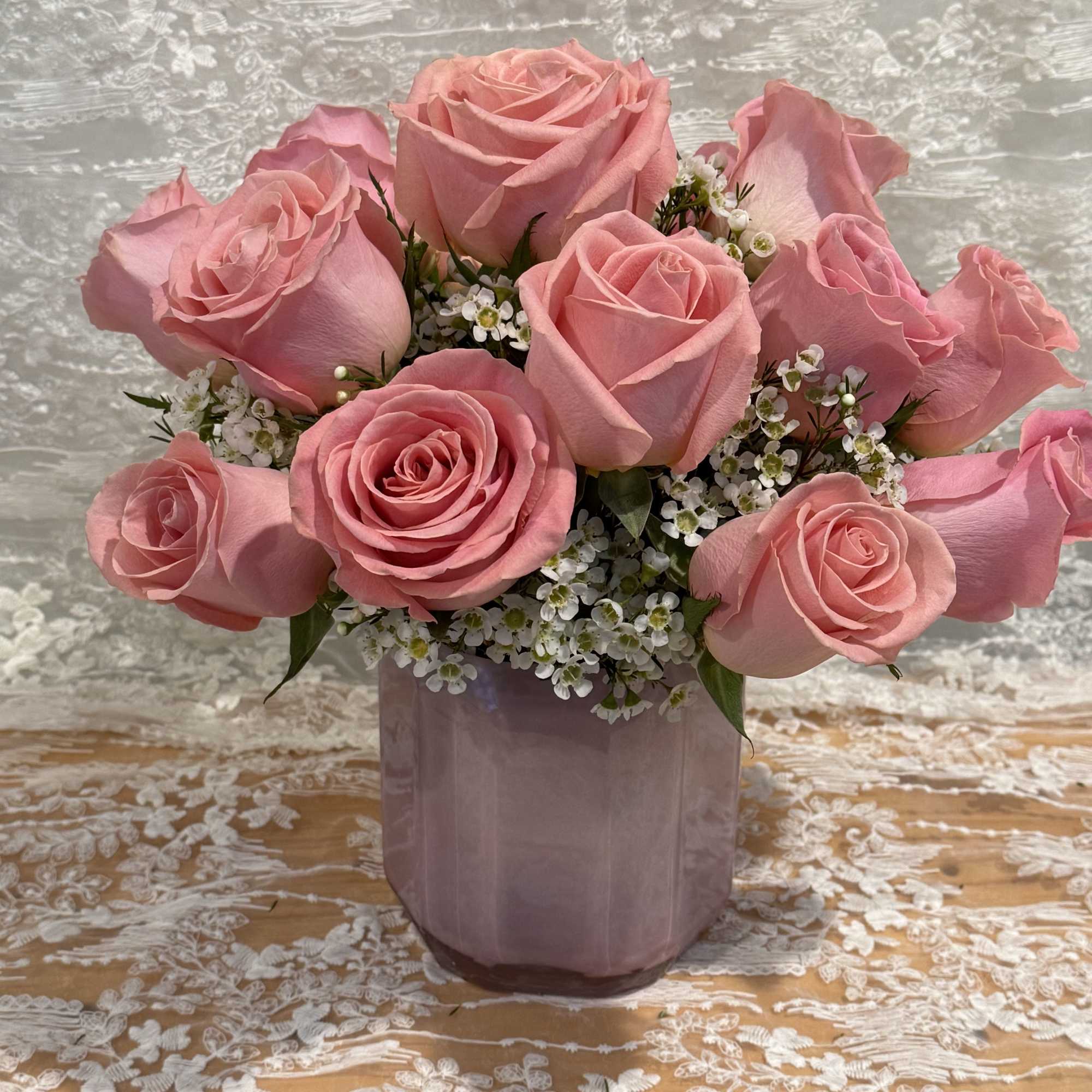 Pink roses with wax flower in a jewel short vase