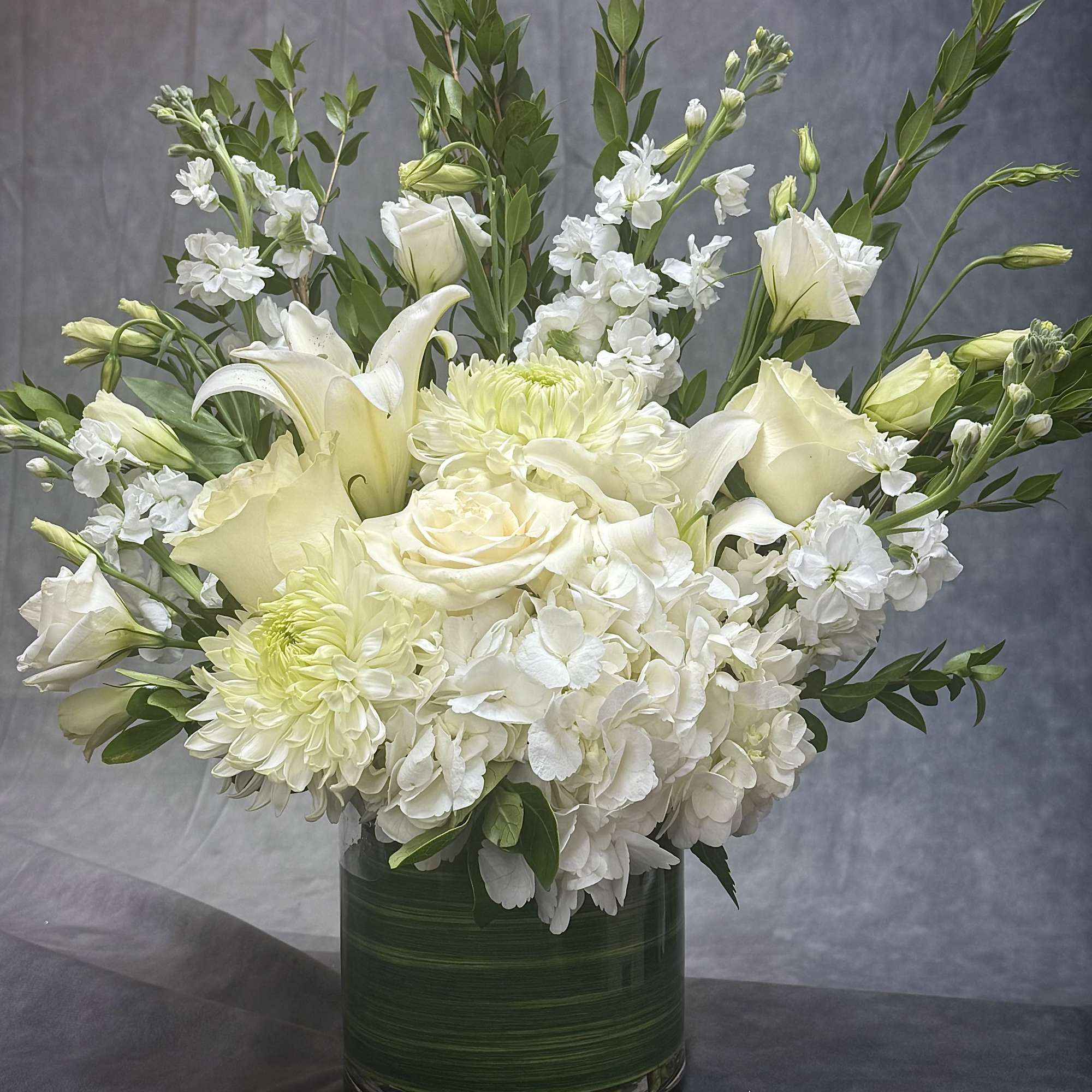 Soft whites and fresh greens come together in this airy arrangement, symbolizing
