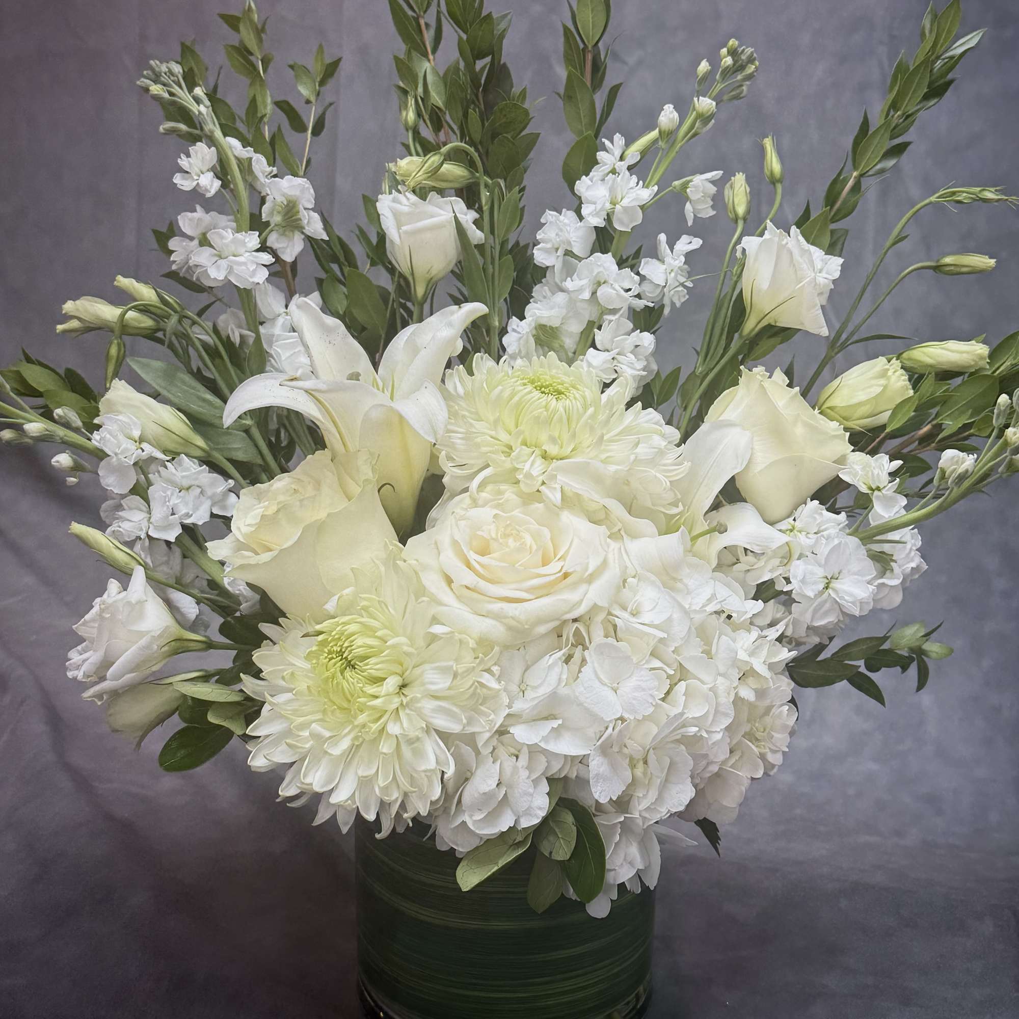 Soft whites and fresh greens come together in this airy arrangement, symbolizing