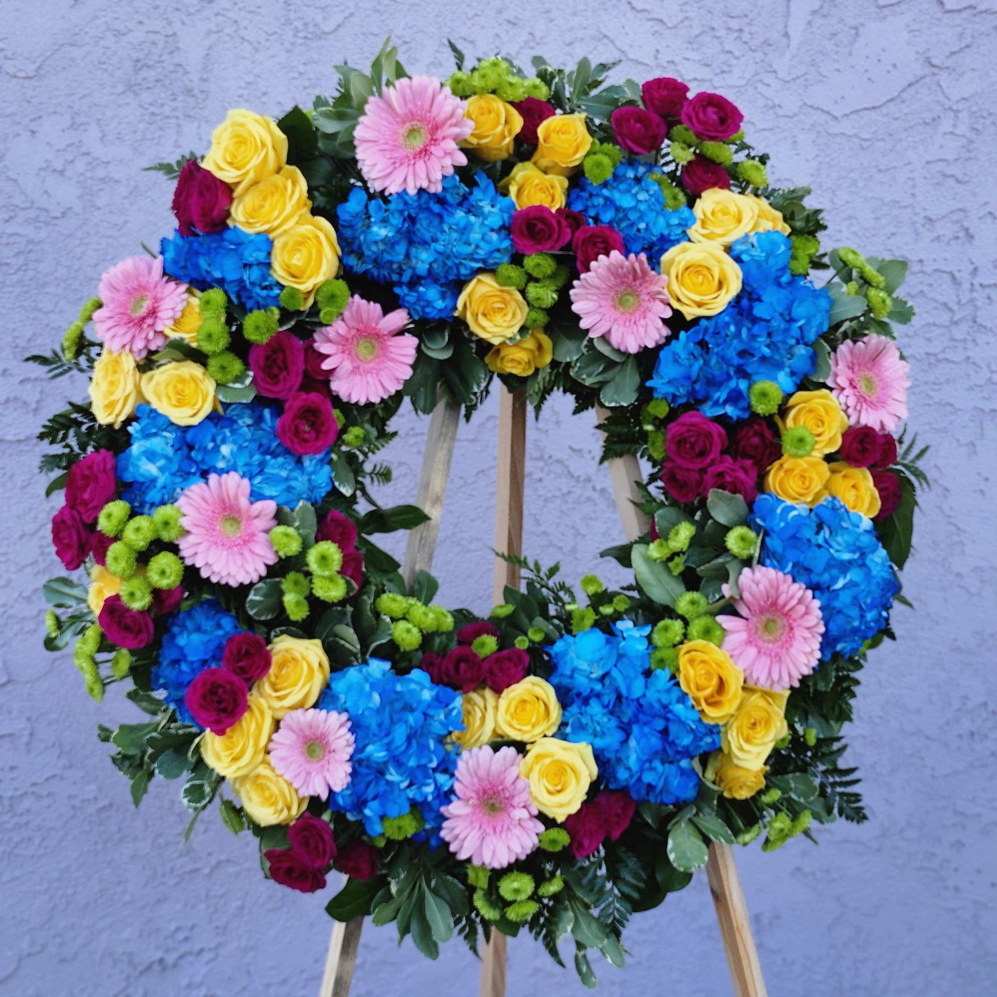 This colorful and bright wreath spray is representative of a life lived