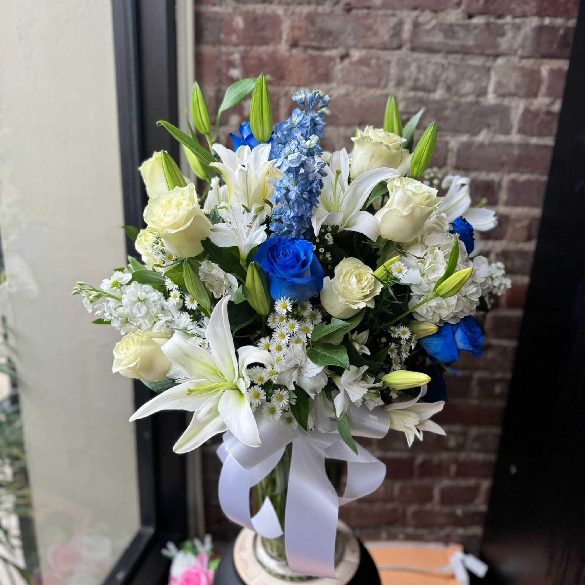 An all white and blue bouquet is designed by experienced designers including