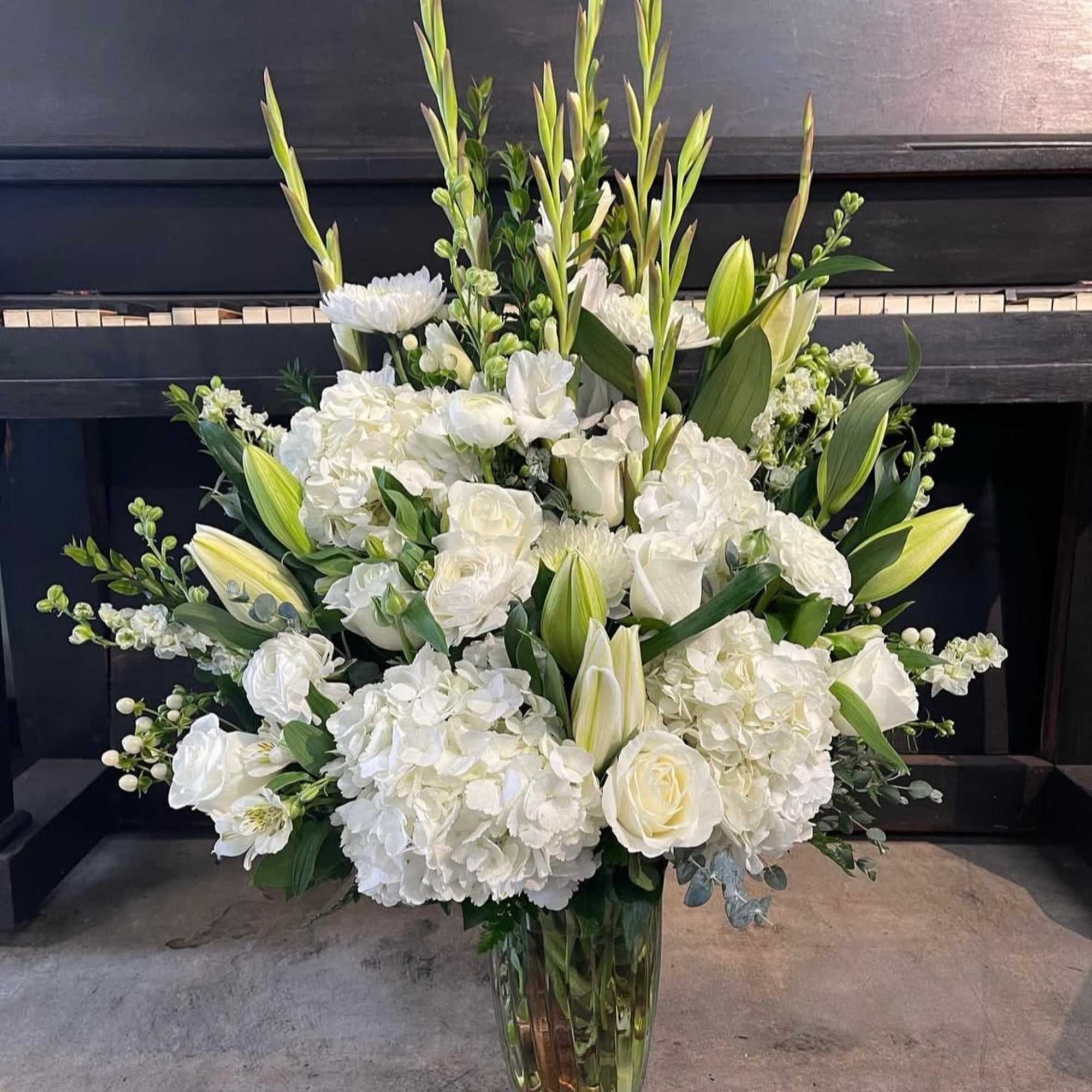This large arrangement includes mixtures of white florals ideal for all occasions.