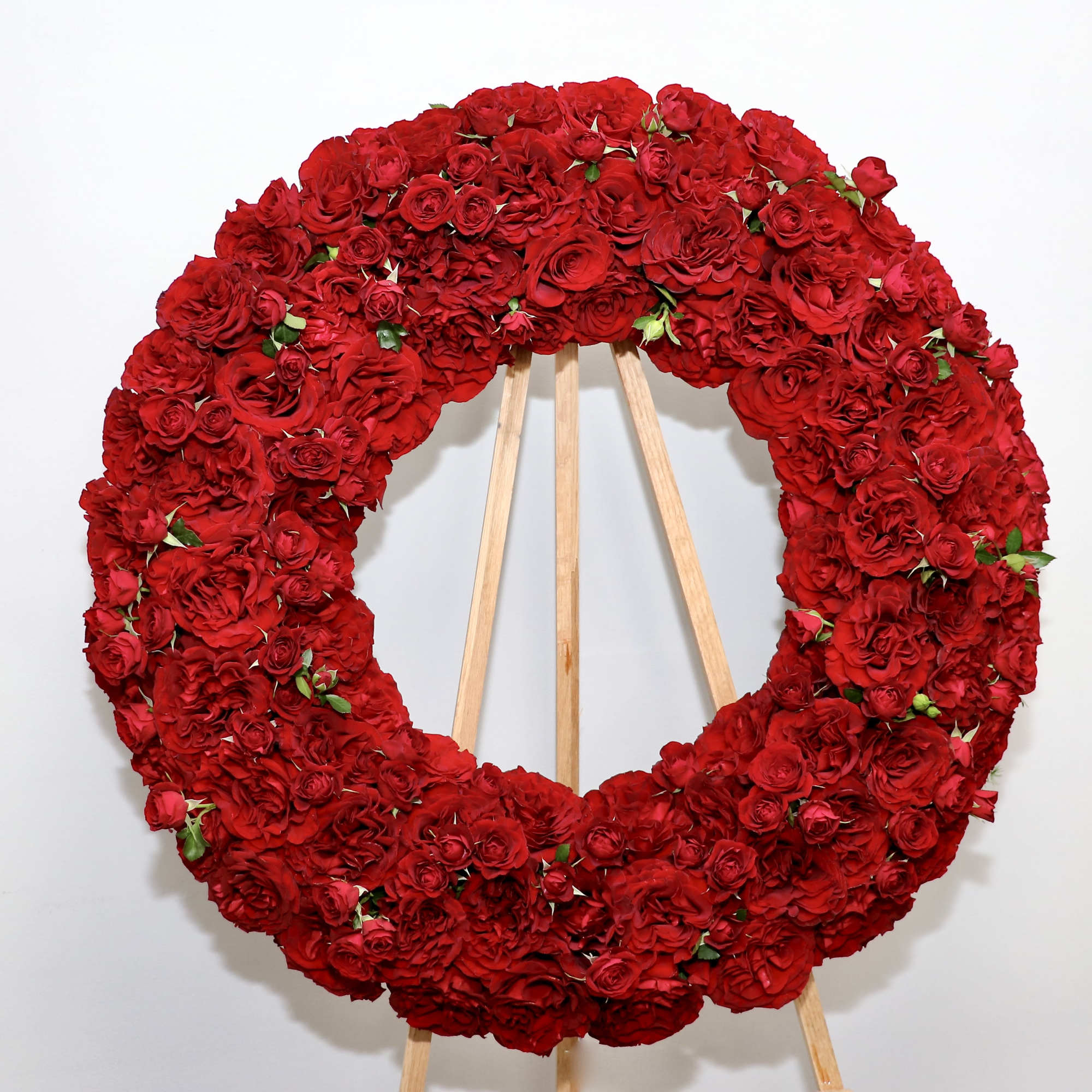 This wreath includes premium Ecuadorian red roses.

We include easel, printed banner and