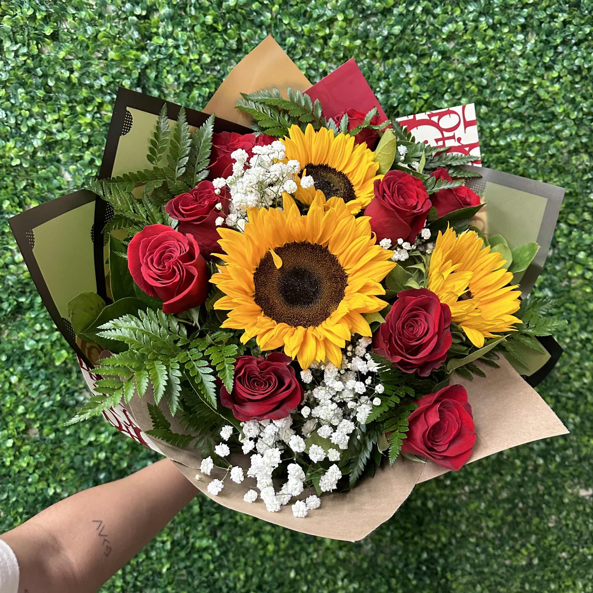 Sunflowers and red roses wrapped in a beautiful hand held bouquet. Nine