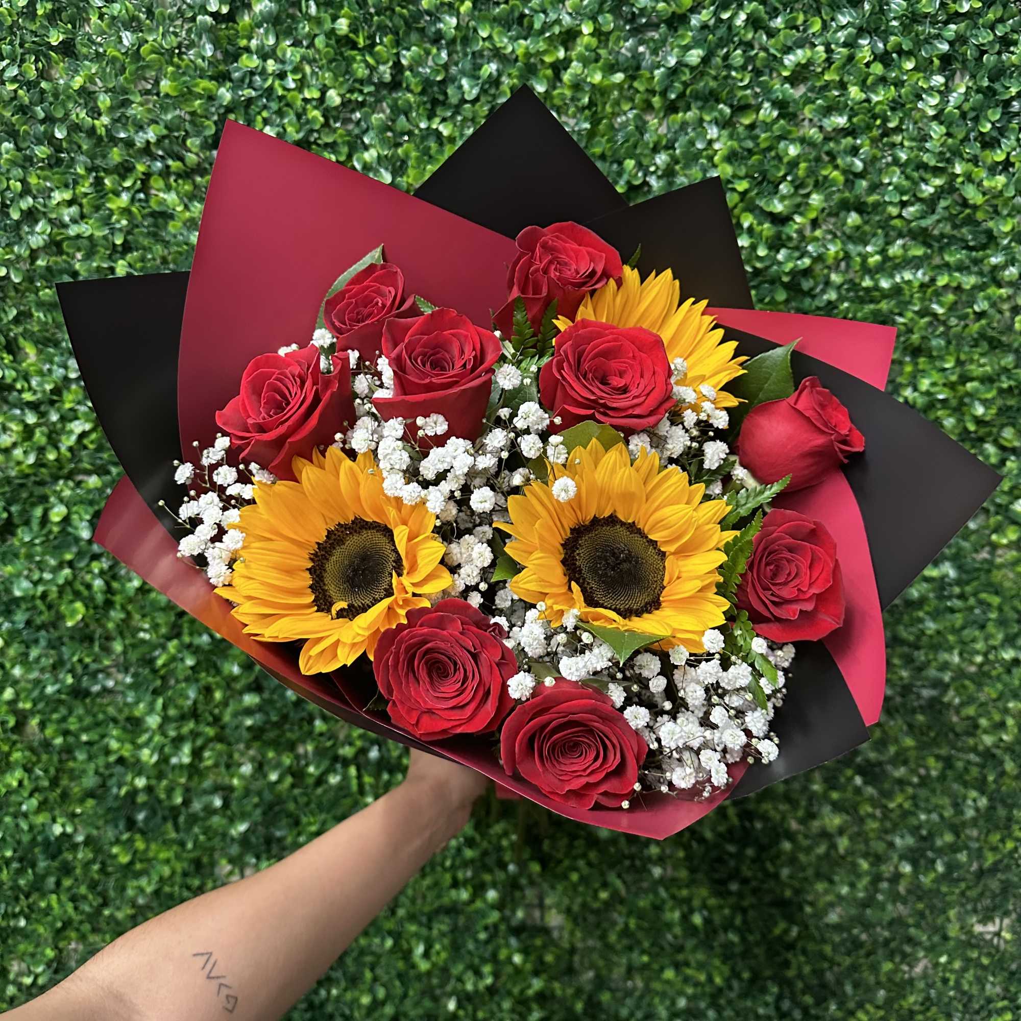 Sunflowers and red roses wrapped in a beautiful hand held bouquet. Nine