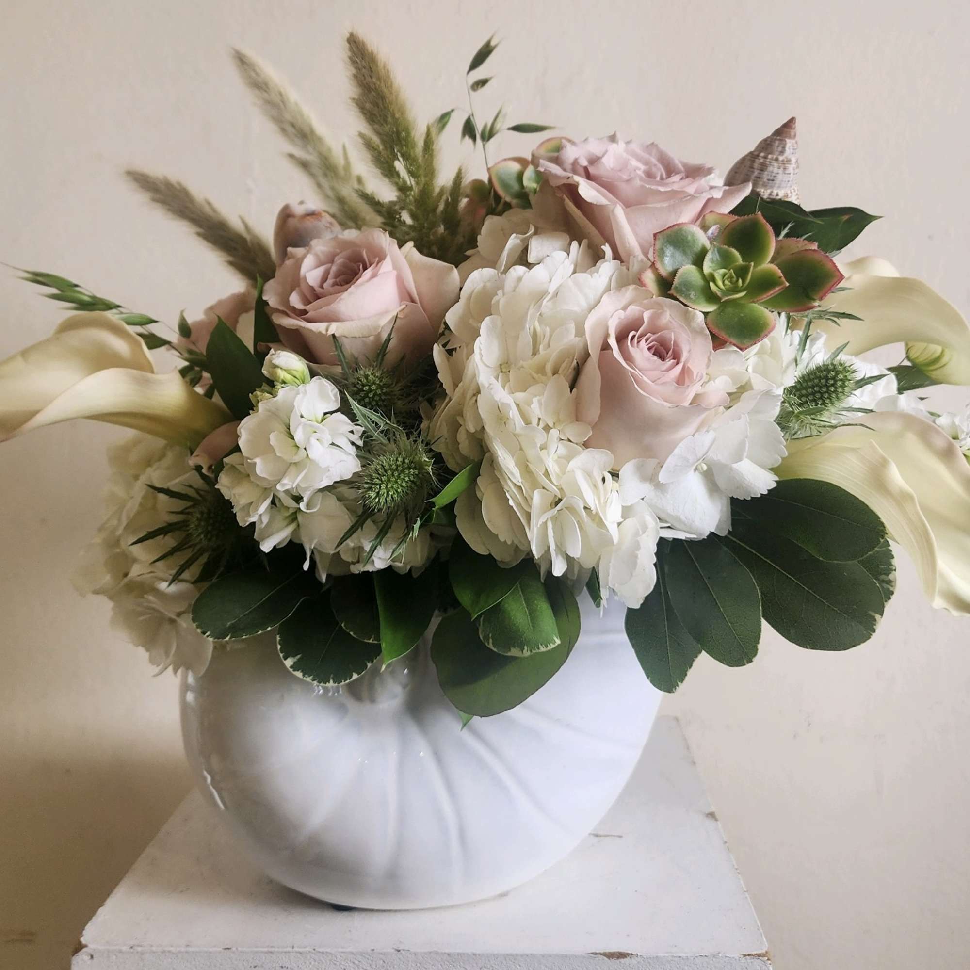 An artistic selection of beautiful eclectic blooms arranged with seascape neutral colors