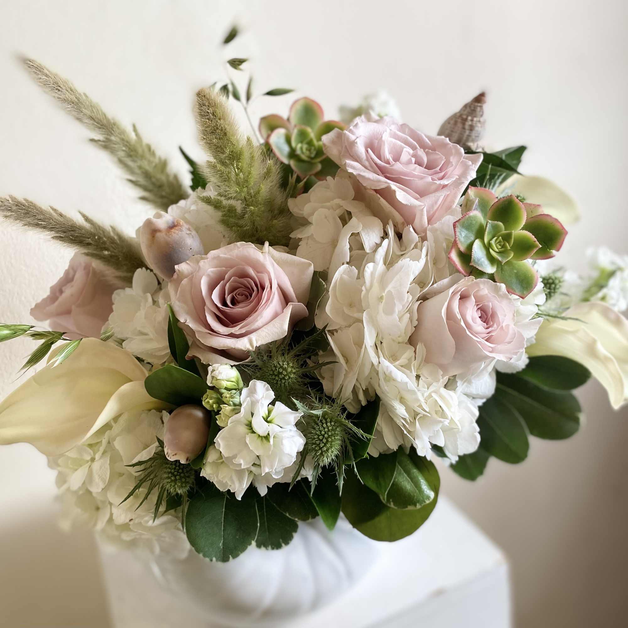 An artistic selection of beautiful eclectic blooms arranged with seascape neutral colors