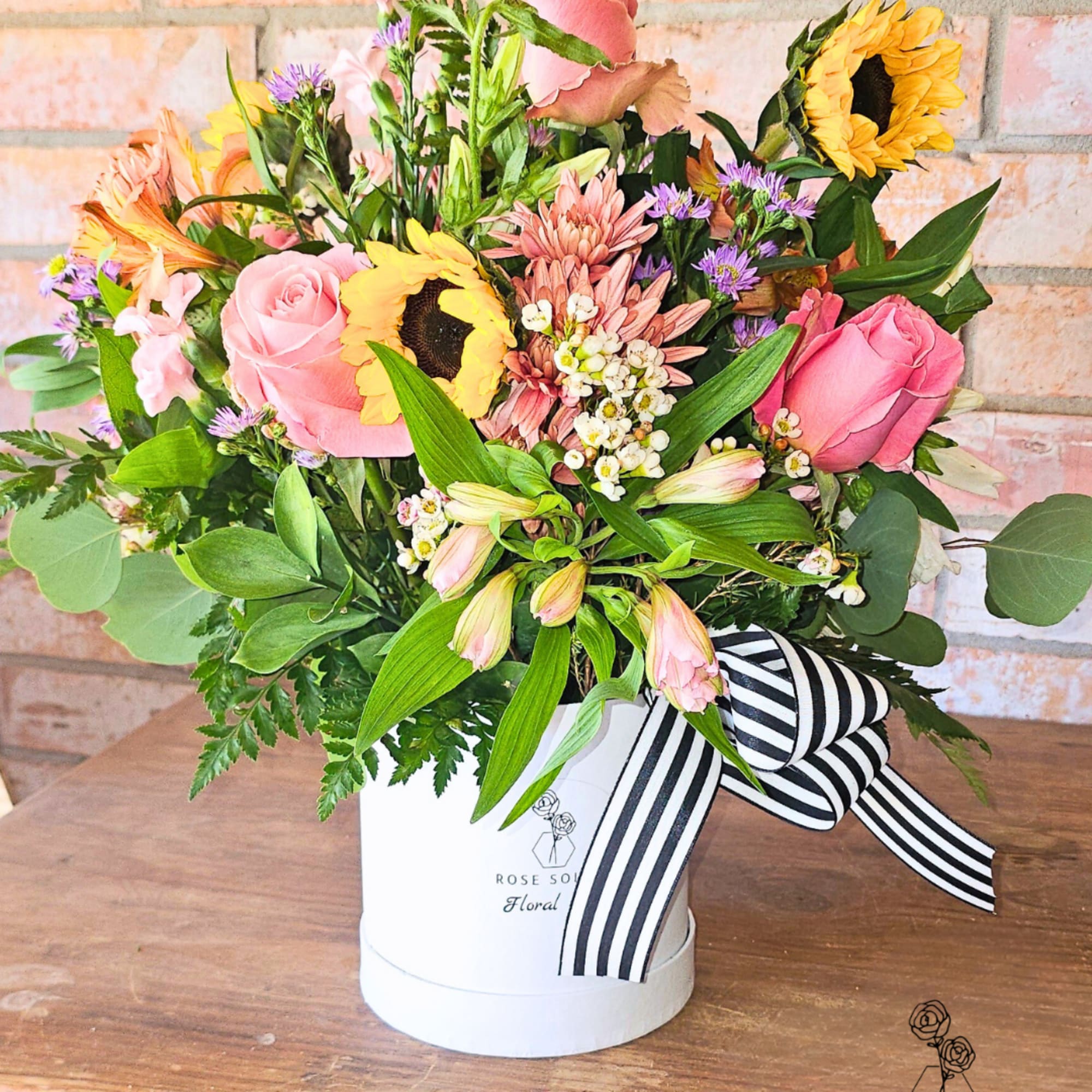 Spring hat box arrangement filled to the brim with vibrant spring florals