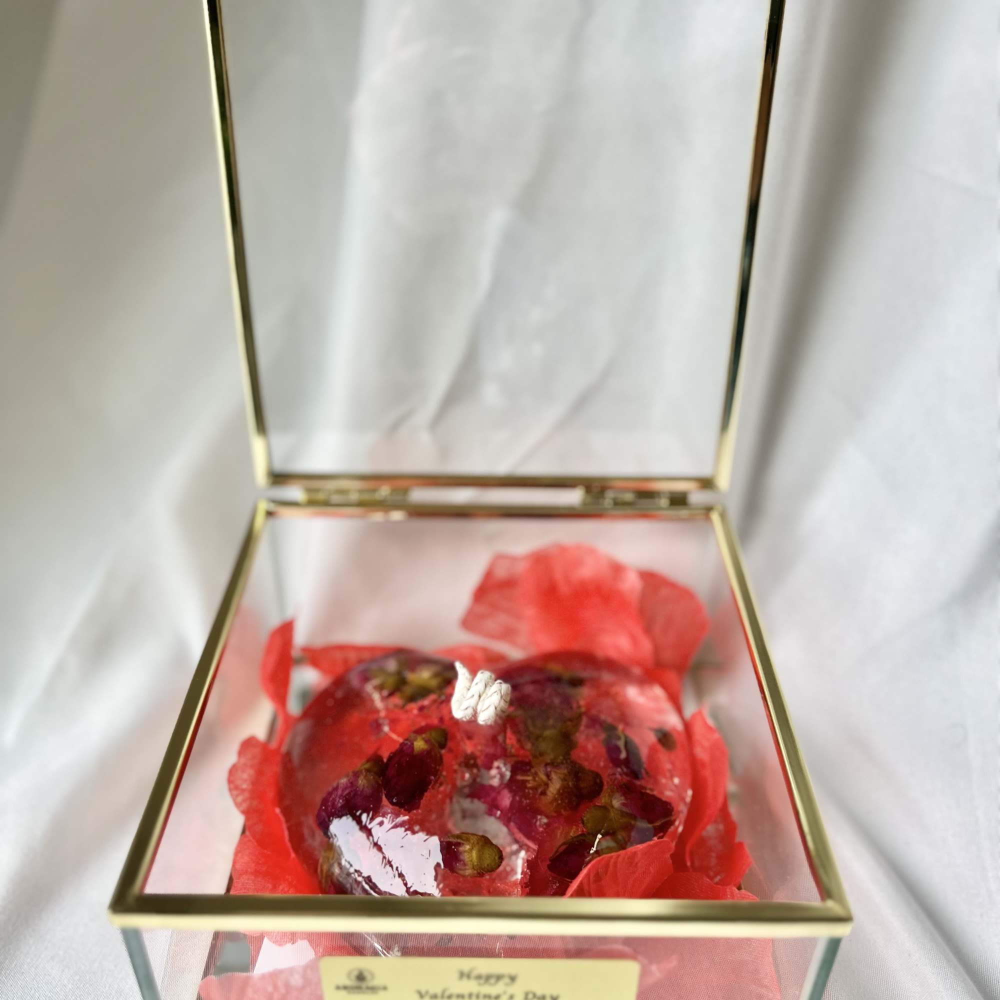 A premium gel candle filled with rose petals and an enchanting rose