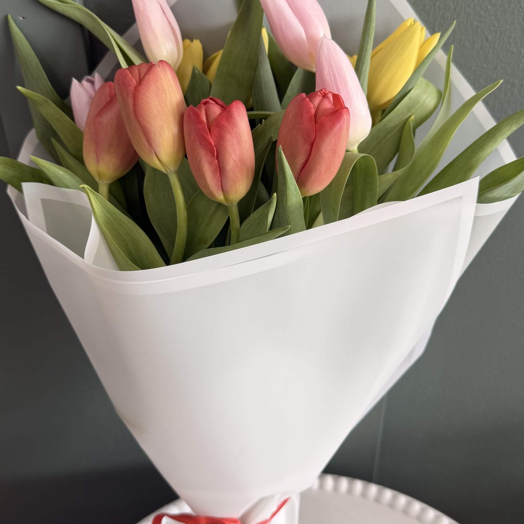 A fresh mix of colorful tulips wrapped in crisp white paper and