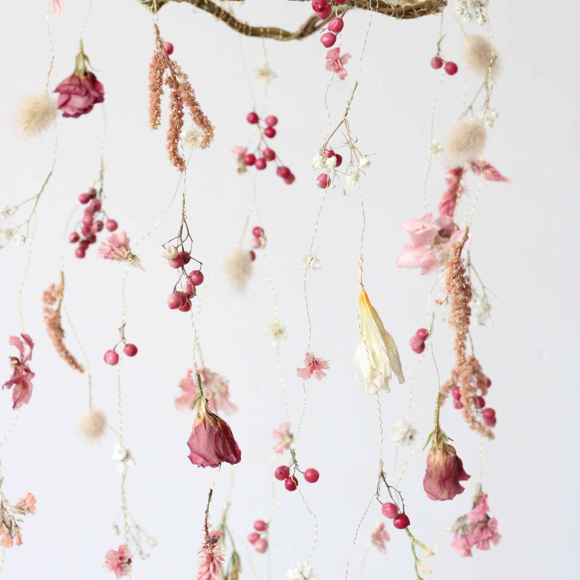 This petite dried floral mobile is a charming, nature-inspired piece that brings