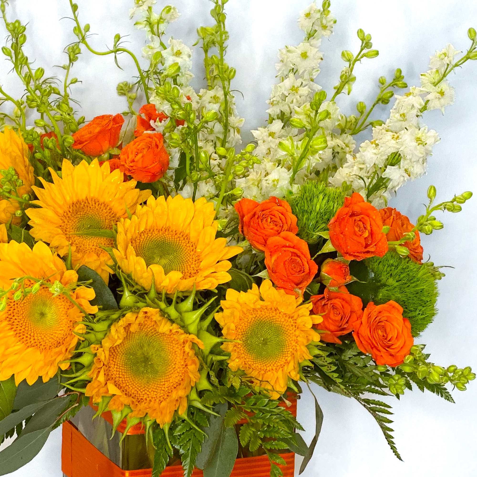 Bright and lovely sunflowers arranged in a centerpiece style with orange equadorian