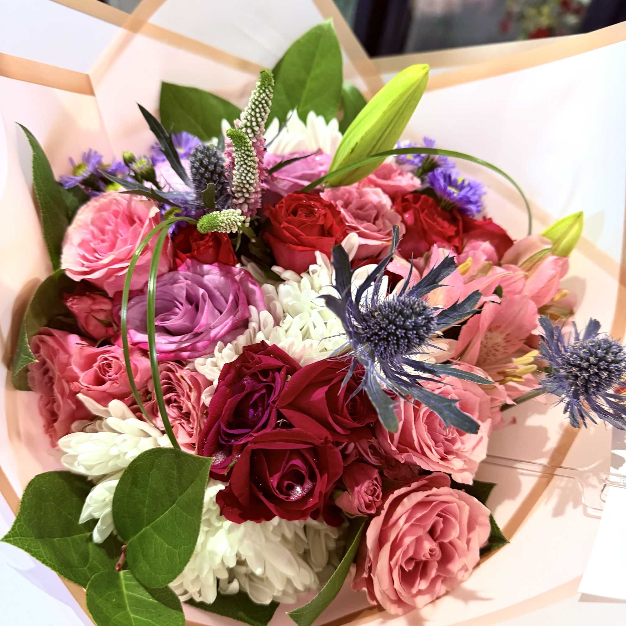 A designer&rsquo;s choice wrapped bouquet featuring 8 radiant roses paired with premium