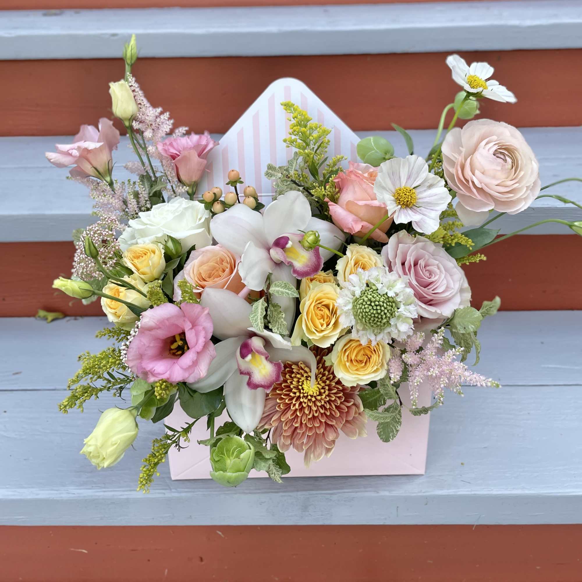 A charming spring arrangement in a soft pink envelope box. Floral varieties
