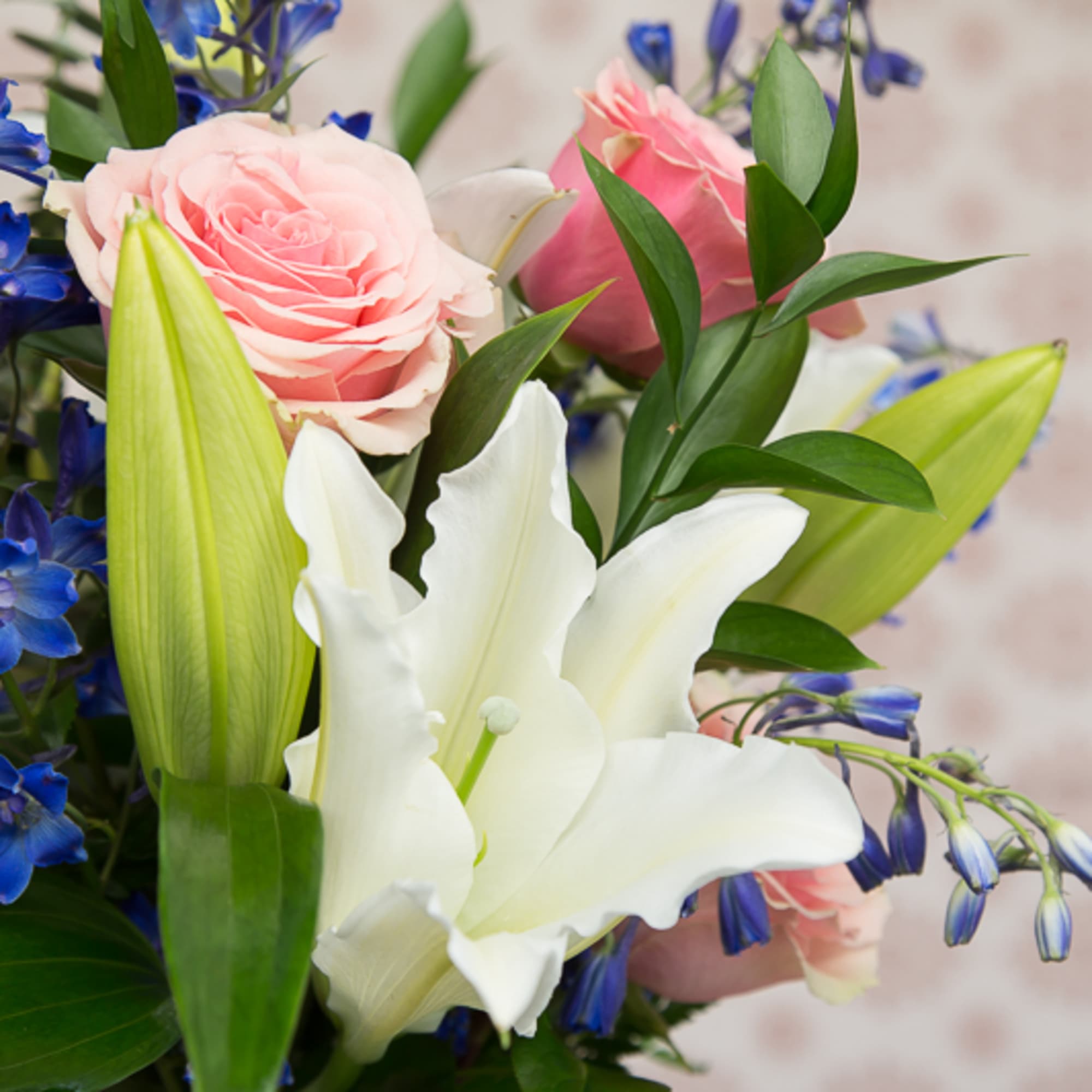 A beautiful arrangement in a tall glass vase full of pink roseswhite