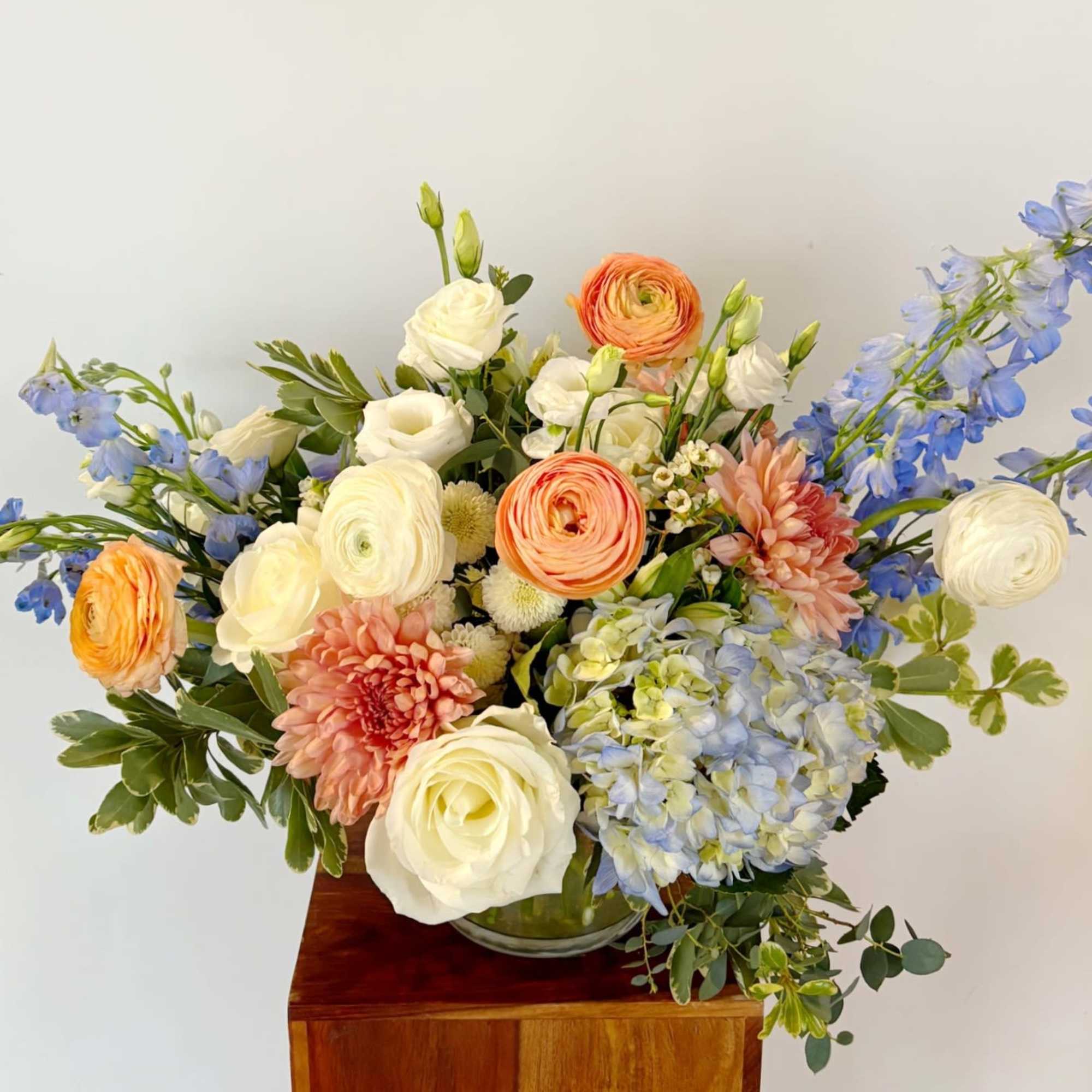 A whimsical assortment of seasonal blooms, unique fillers, and dried goods. A