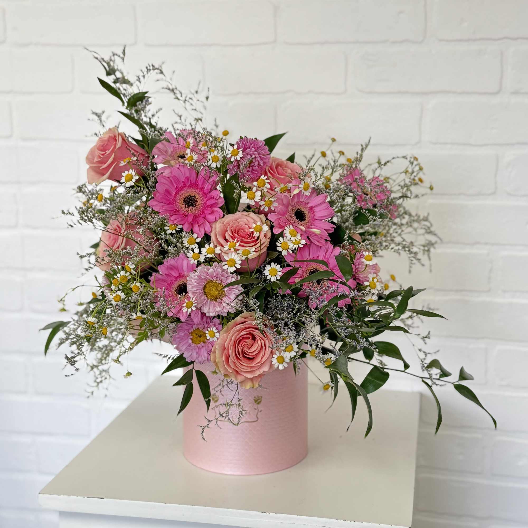 A garden of fresh pink blooms mixed with greens in a chic