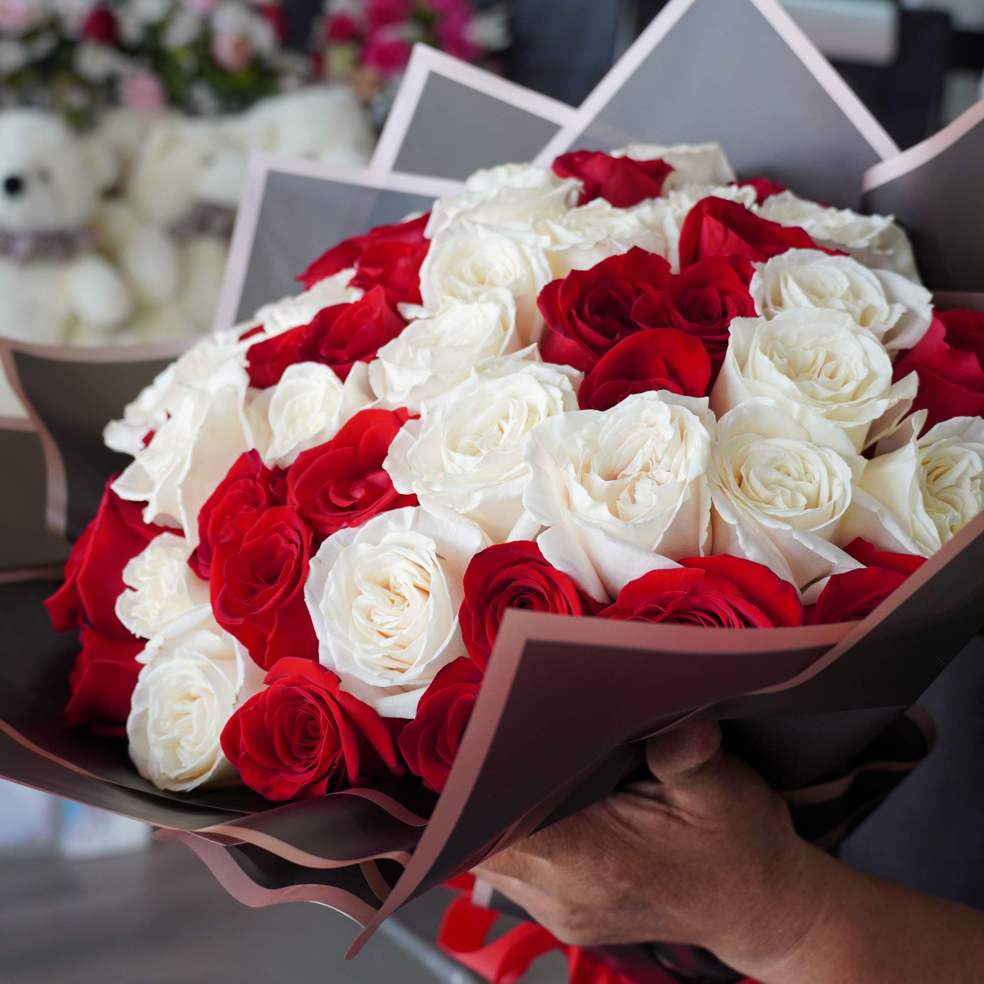 An elegant mix of 50 red and white roses, beautifully arranged in