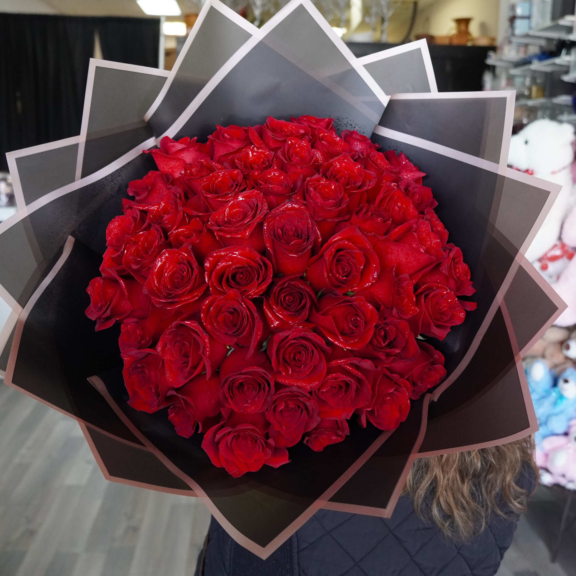 A stunning hand tied bouquet of premium red roses wrapped in sleek