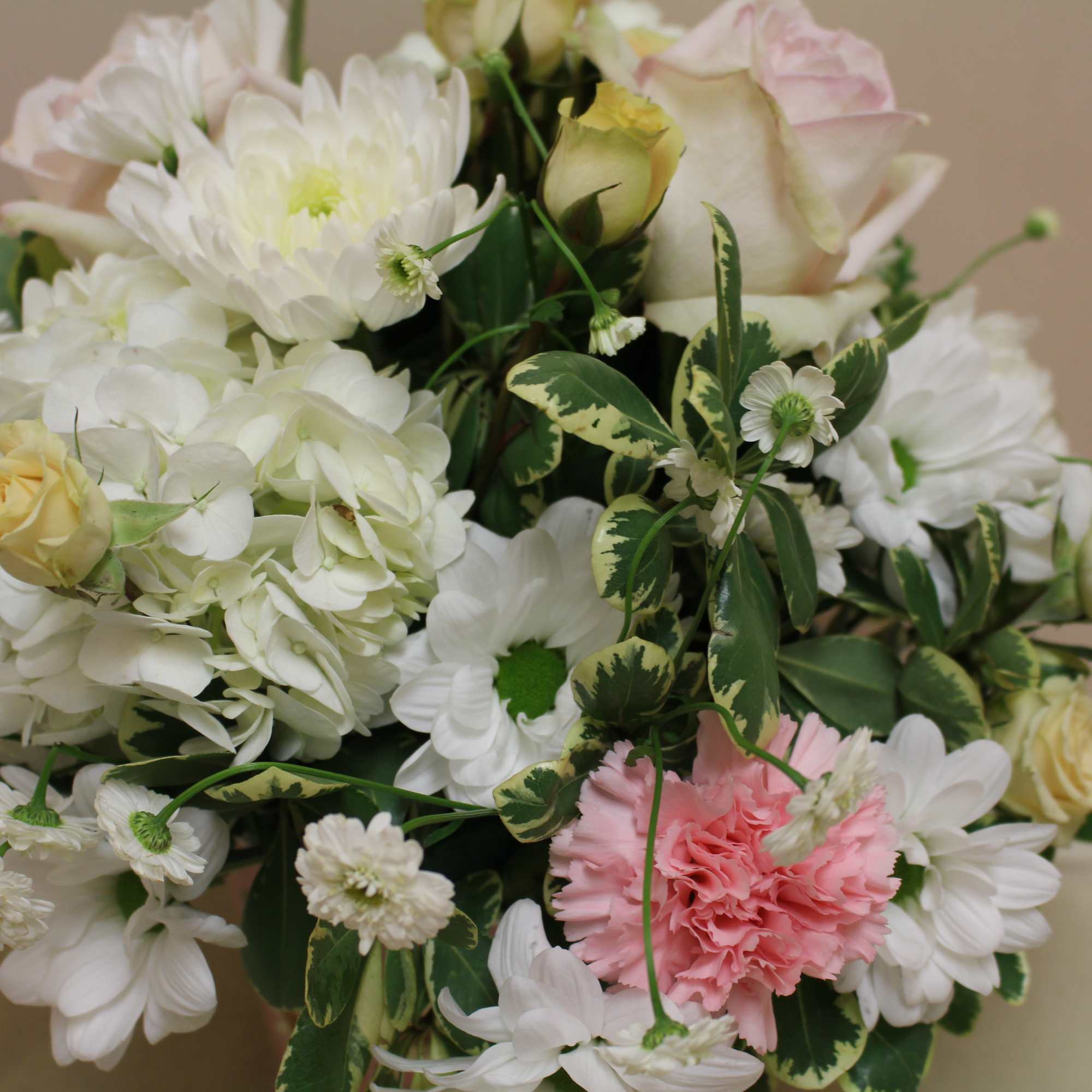 A summer arrangement with pale yellows, pink and whites.  All in