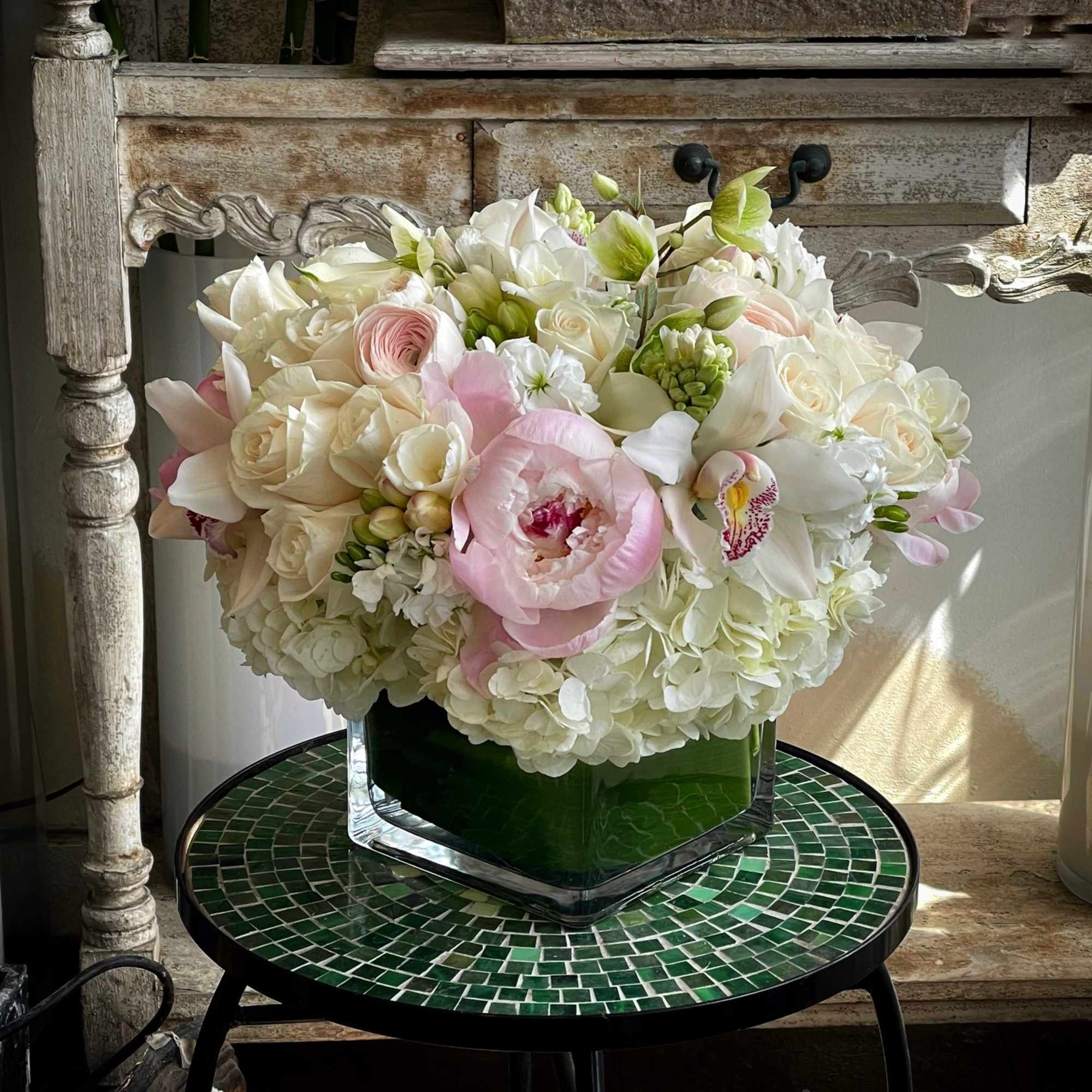 Hydrangea, Premium Roses, Peonies, Cymbidium Orchid and more in square vases.