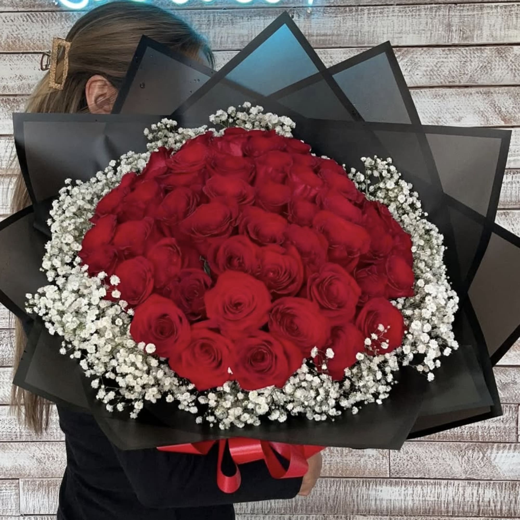 50 of our premium red roses wrapped with babies breath. Accompanied by