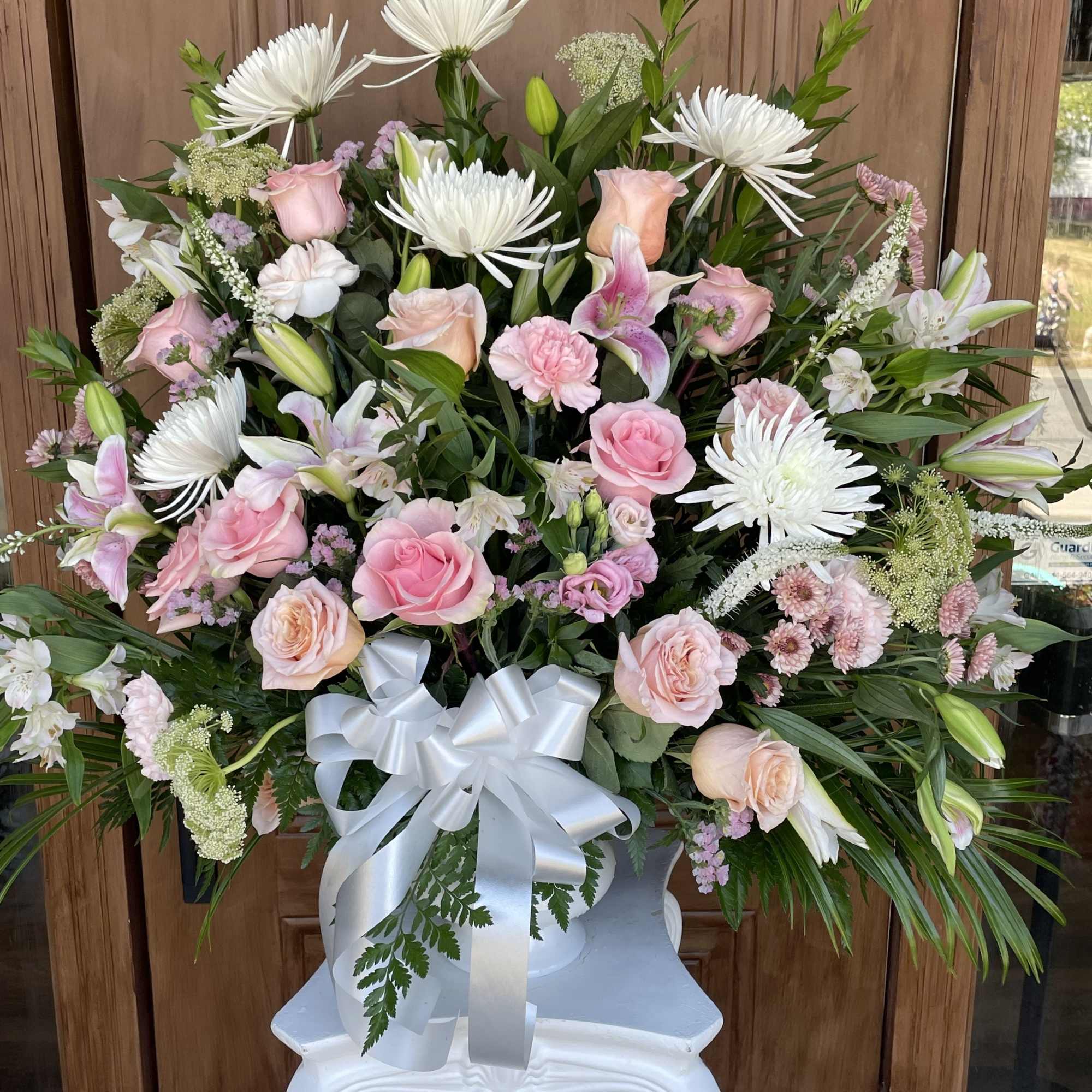 This pink and white funeral basket is a lovely sendoff and tribute.