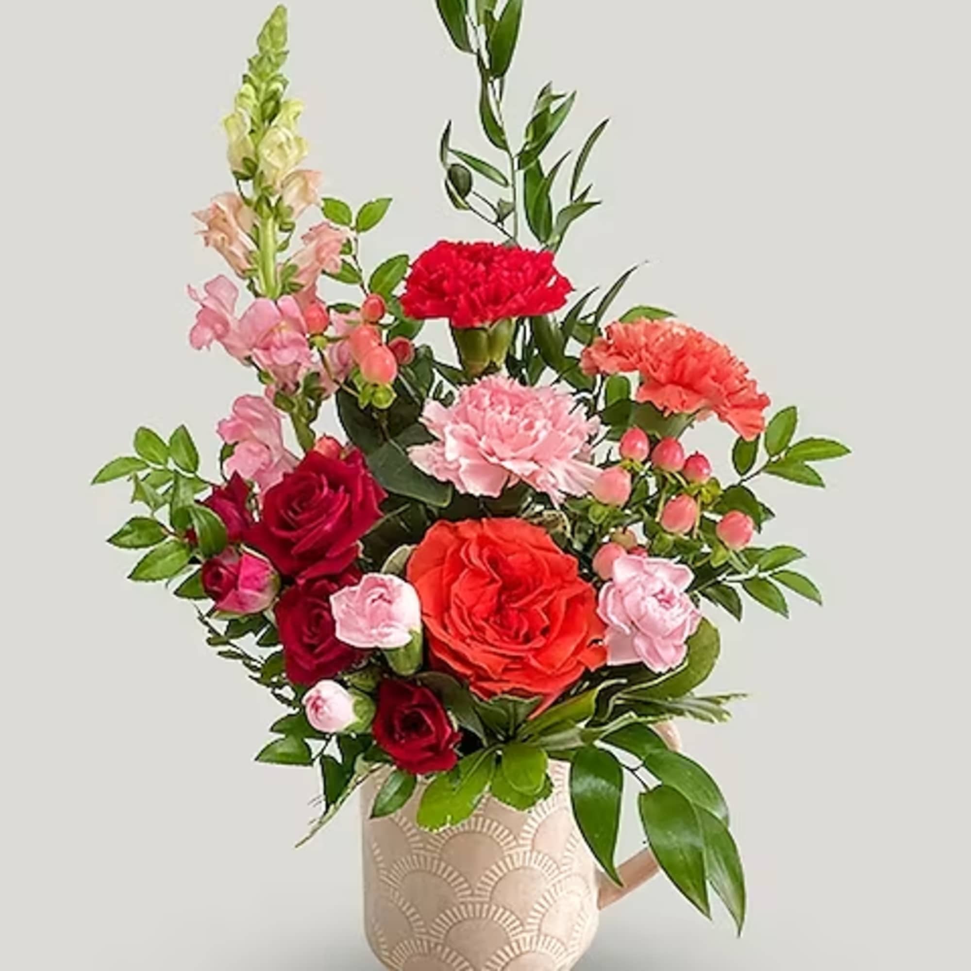 A cozy arrangement filled with long lasting carnations, a snapdragon, hypericum berries