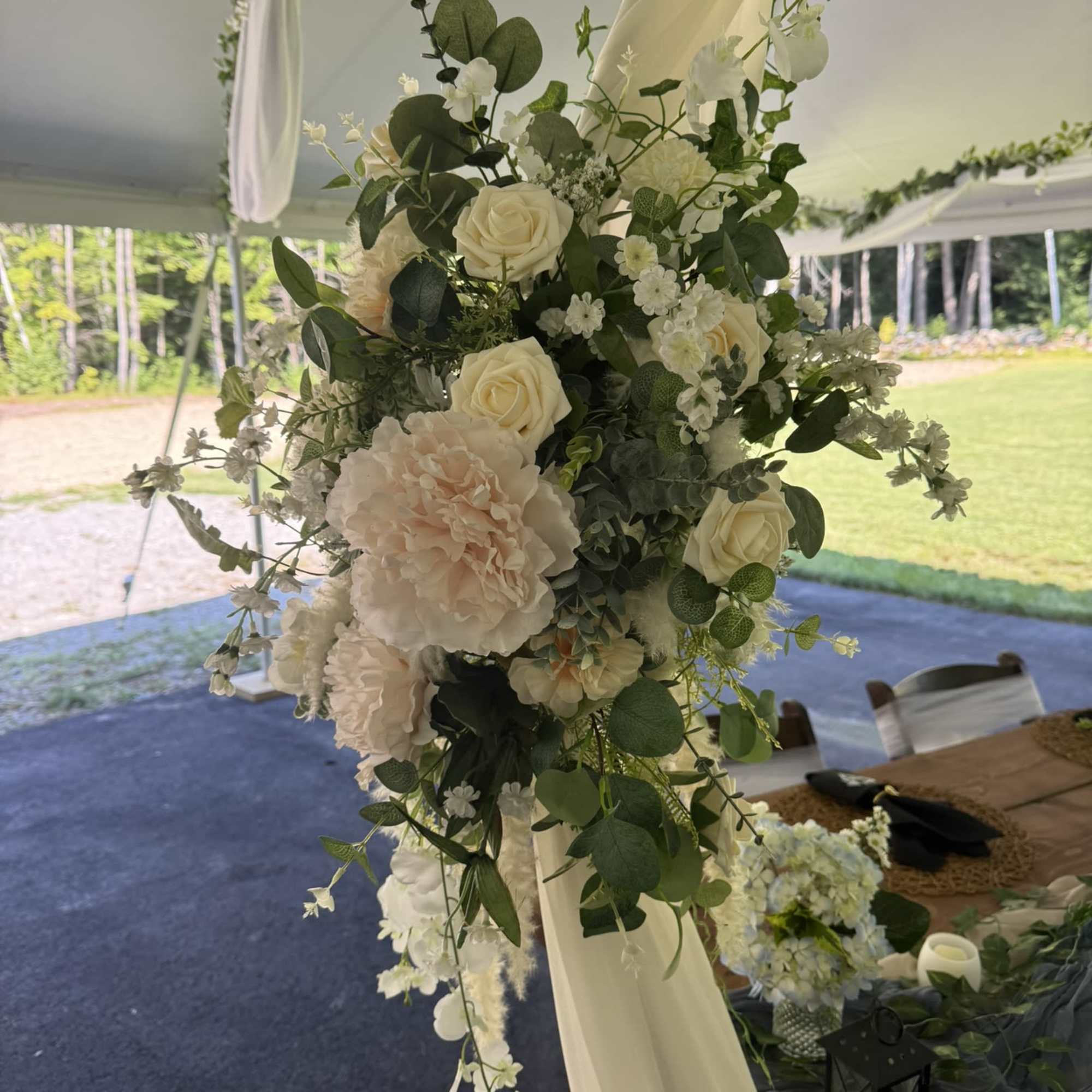 A beautifully styled floral arch designed with soft blooms and flowing greenery