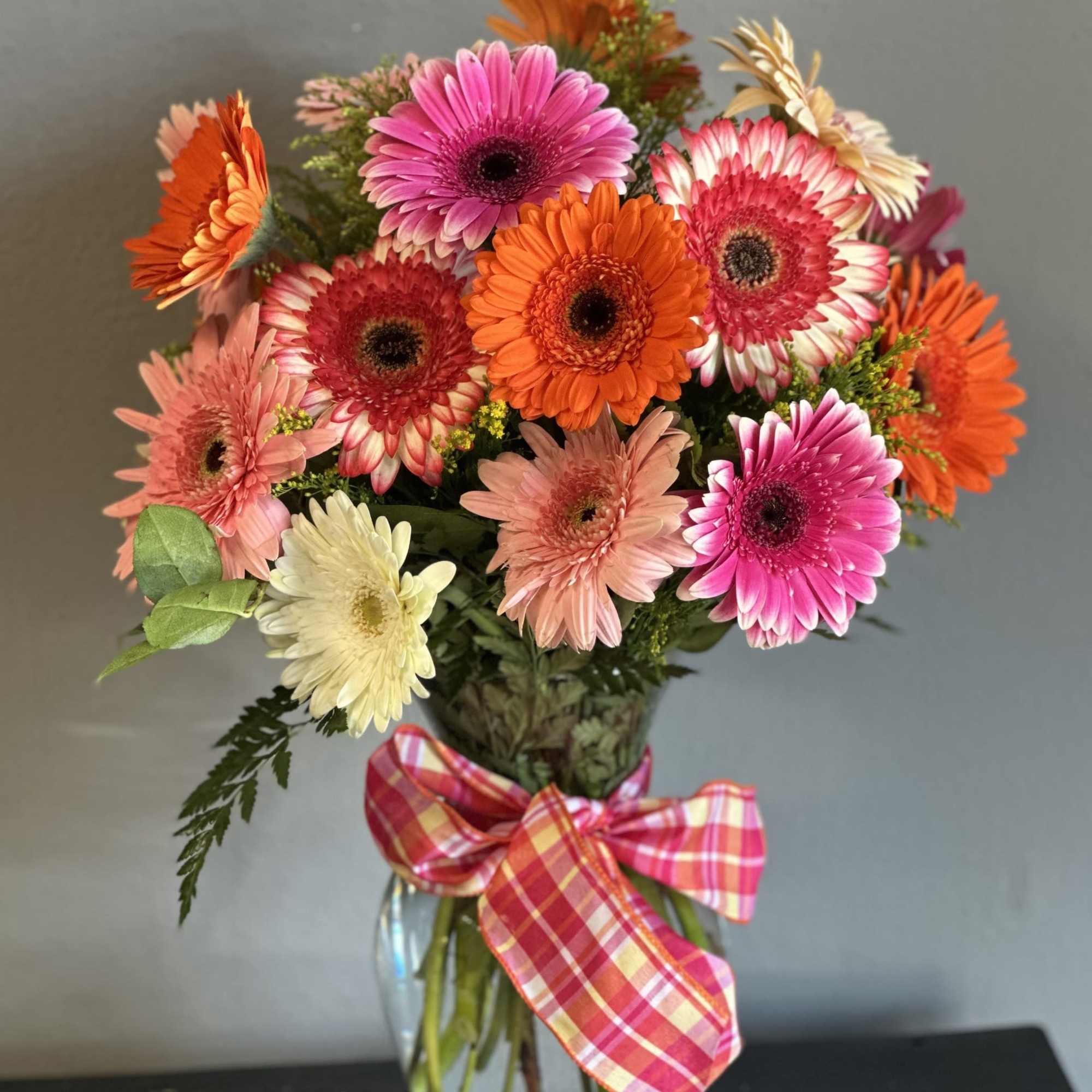 A lovely, cheerful mix of a dozen gerbera daisies and greens in