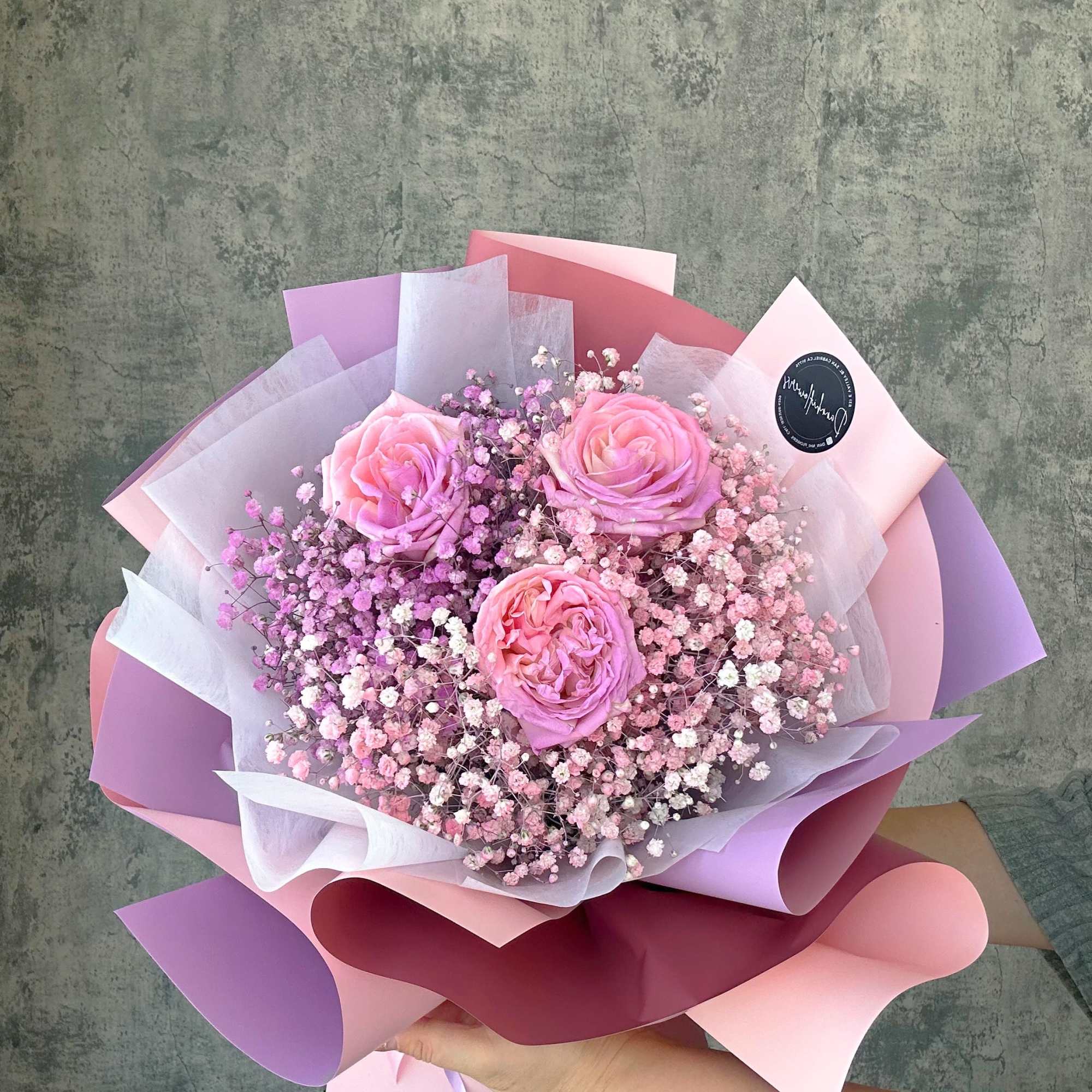 3 roses bi-color bouquet on the bed of baby's breath