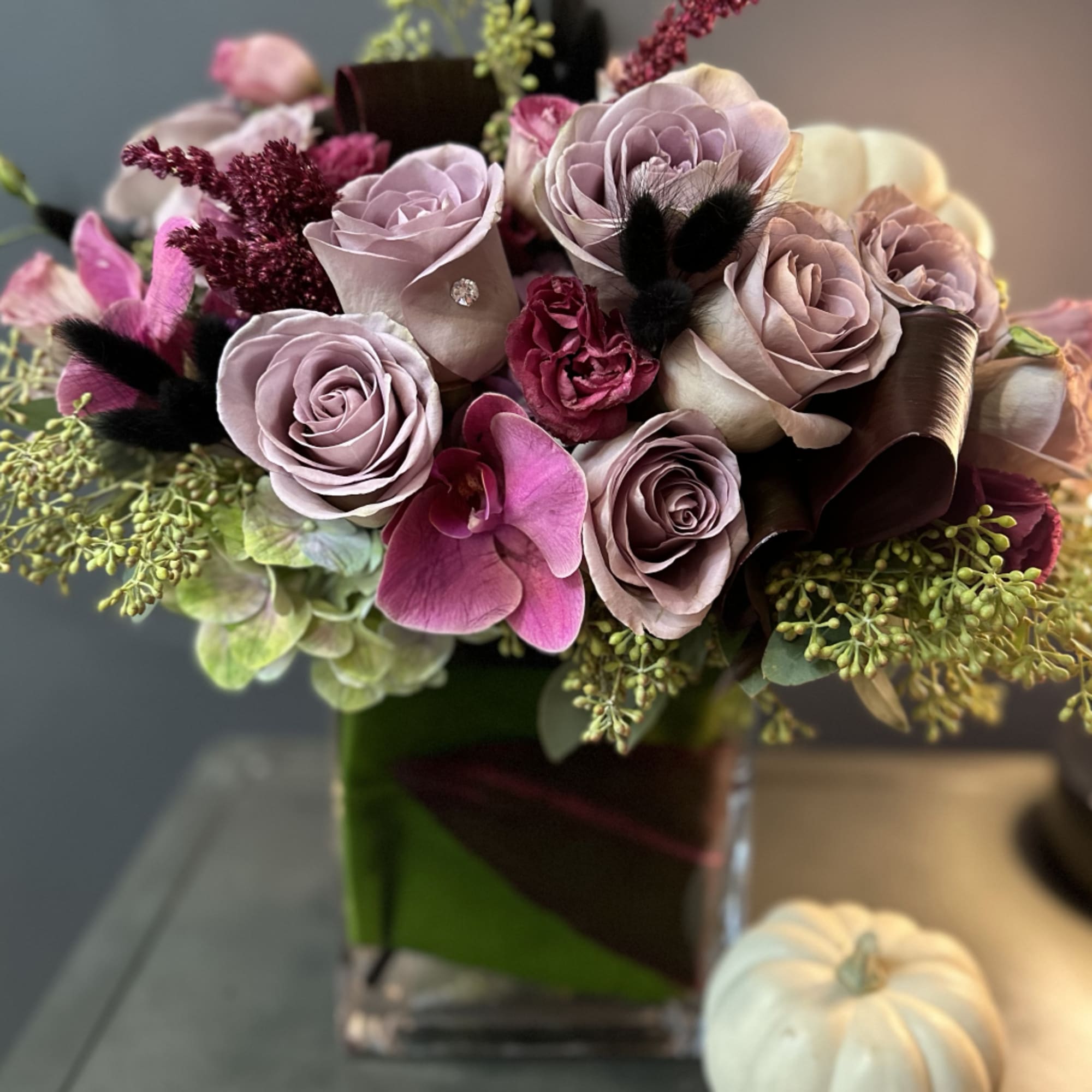 A beautifully designed abundance of Amnesia roses, plum lisianthus, amaranth, eucalyptus, and