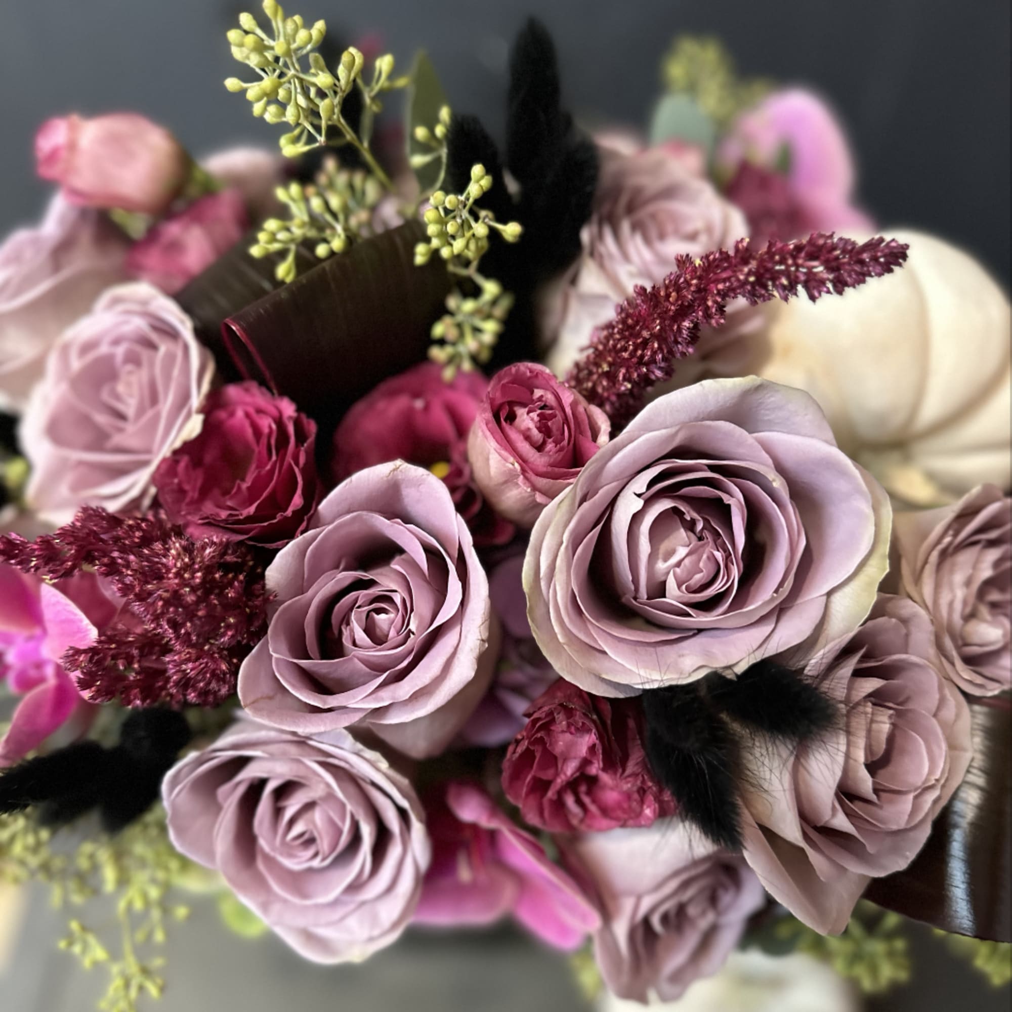A beautifully designed abundance of Amnesia roses, plum lisianthus, amaranth, eucalyptus, and