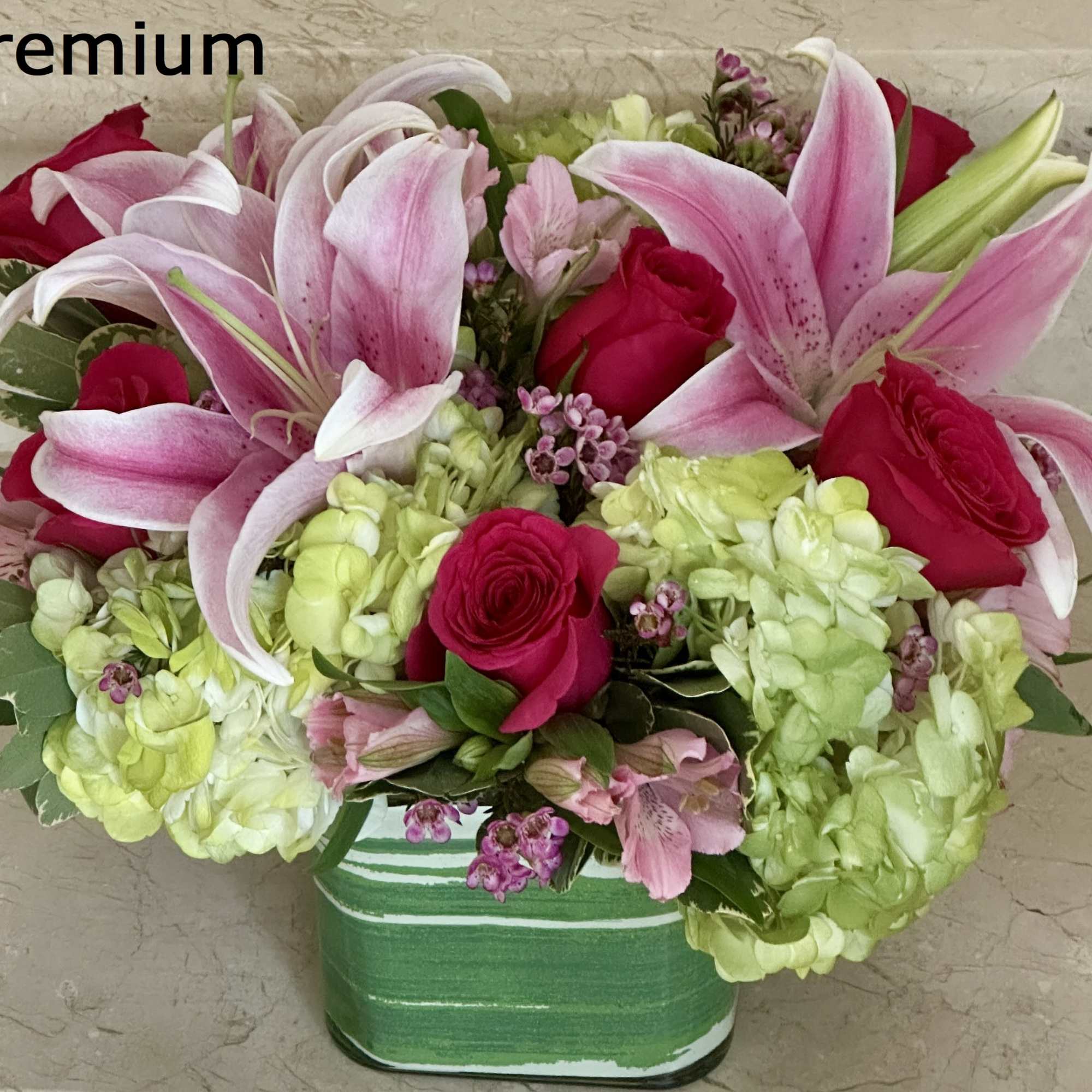 Roses, Hydraengas, Lillies and other flowers arranged in a glass cube. The