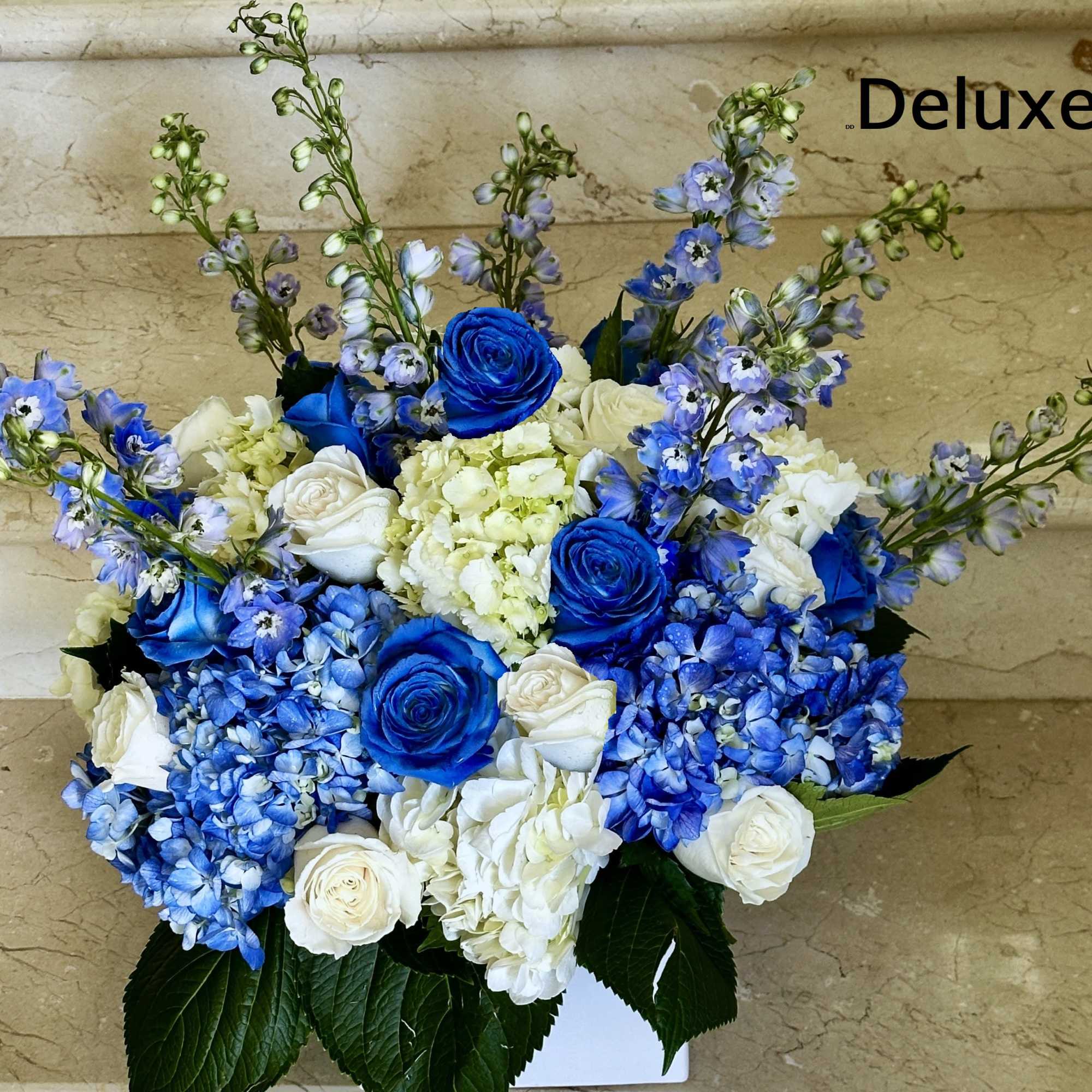 Featuring tall, elegant delphinium in shades of blue and lavender, paired with