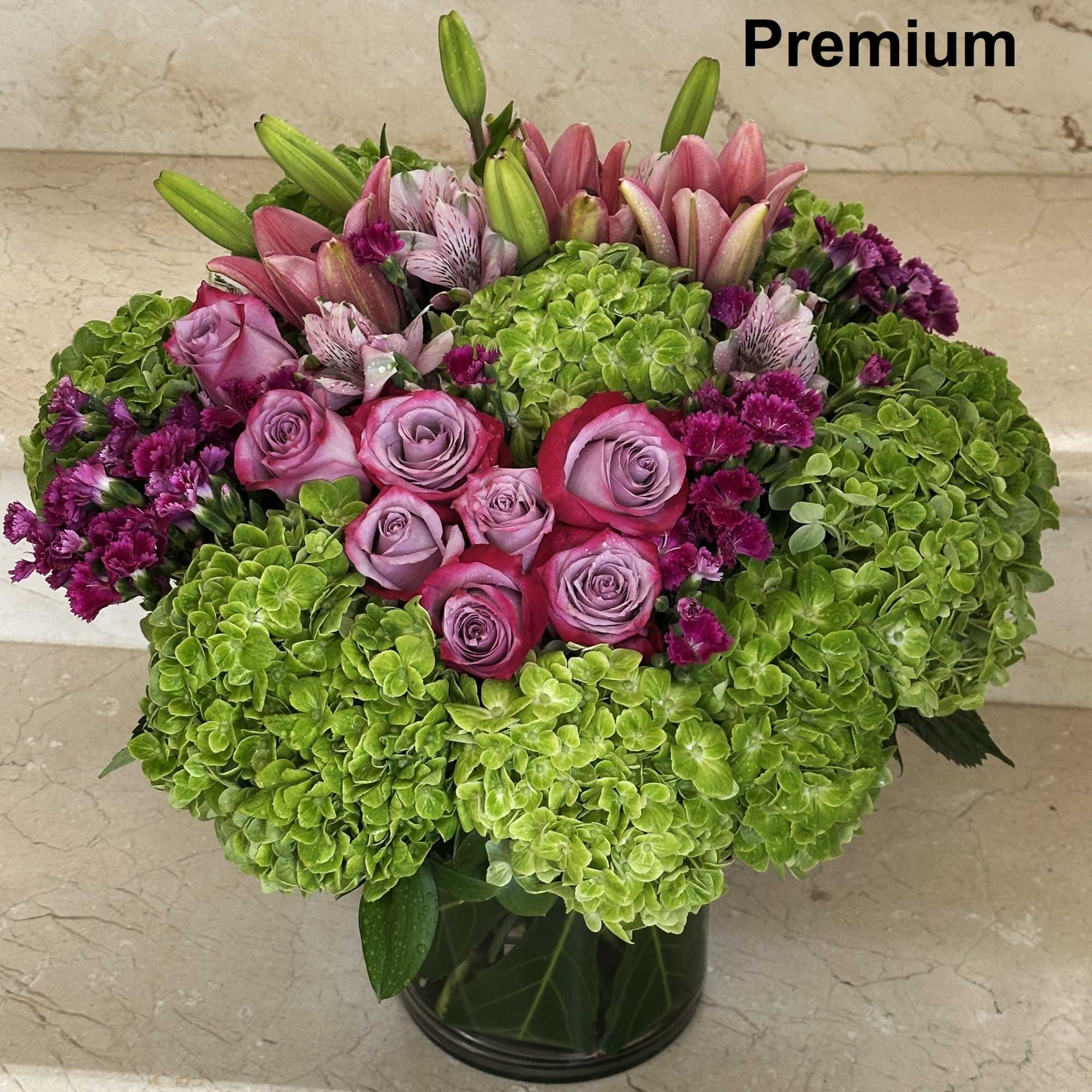 Hydrangeas, Roses, Lilies and other flowers. Arranged in a clear glass vase