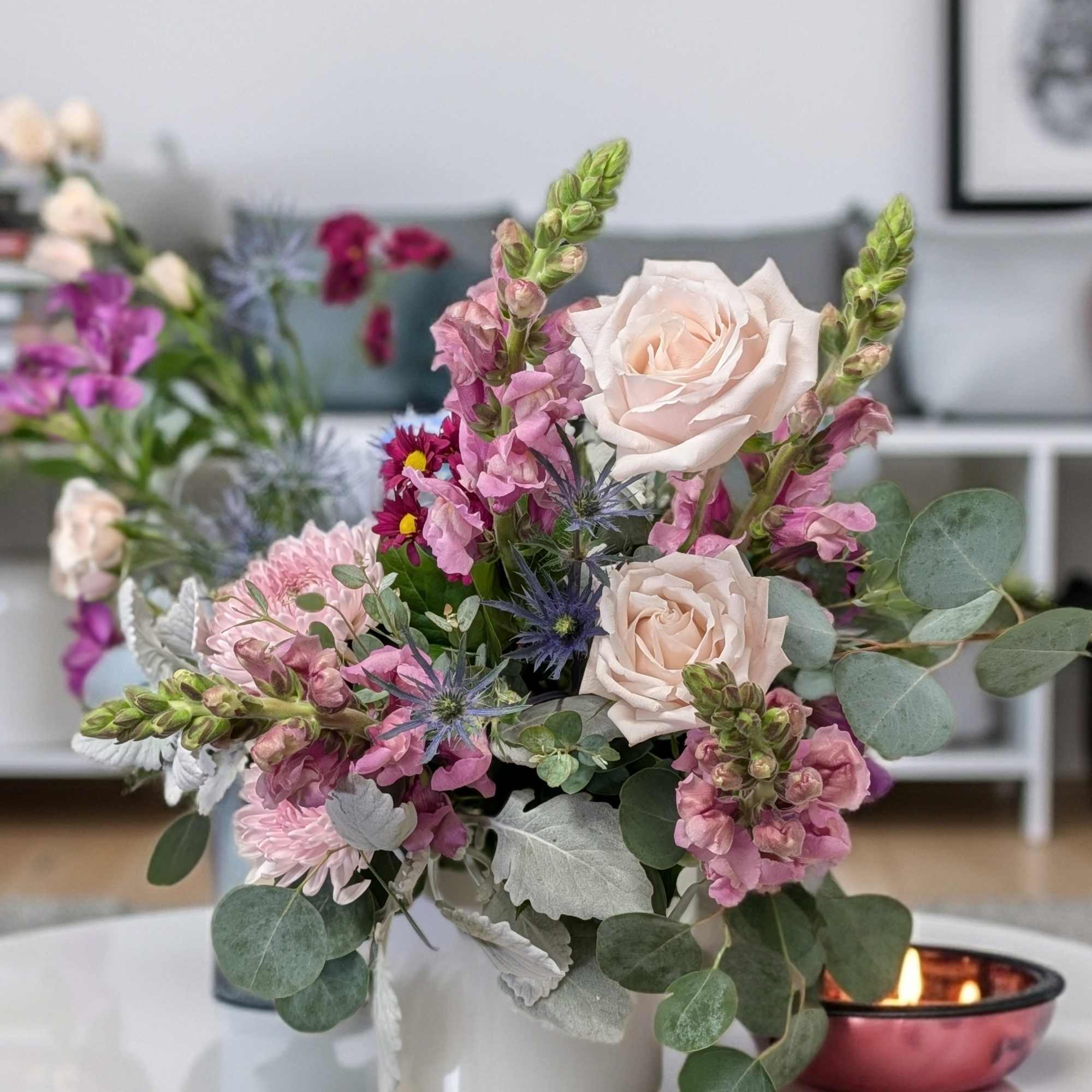 A vibrant display of Spring seasonal flowers in a white ceramic.