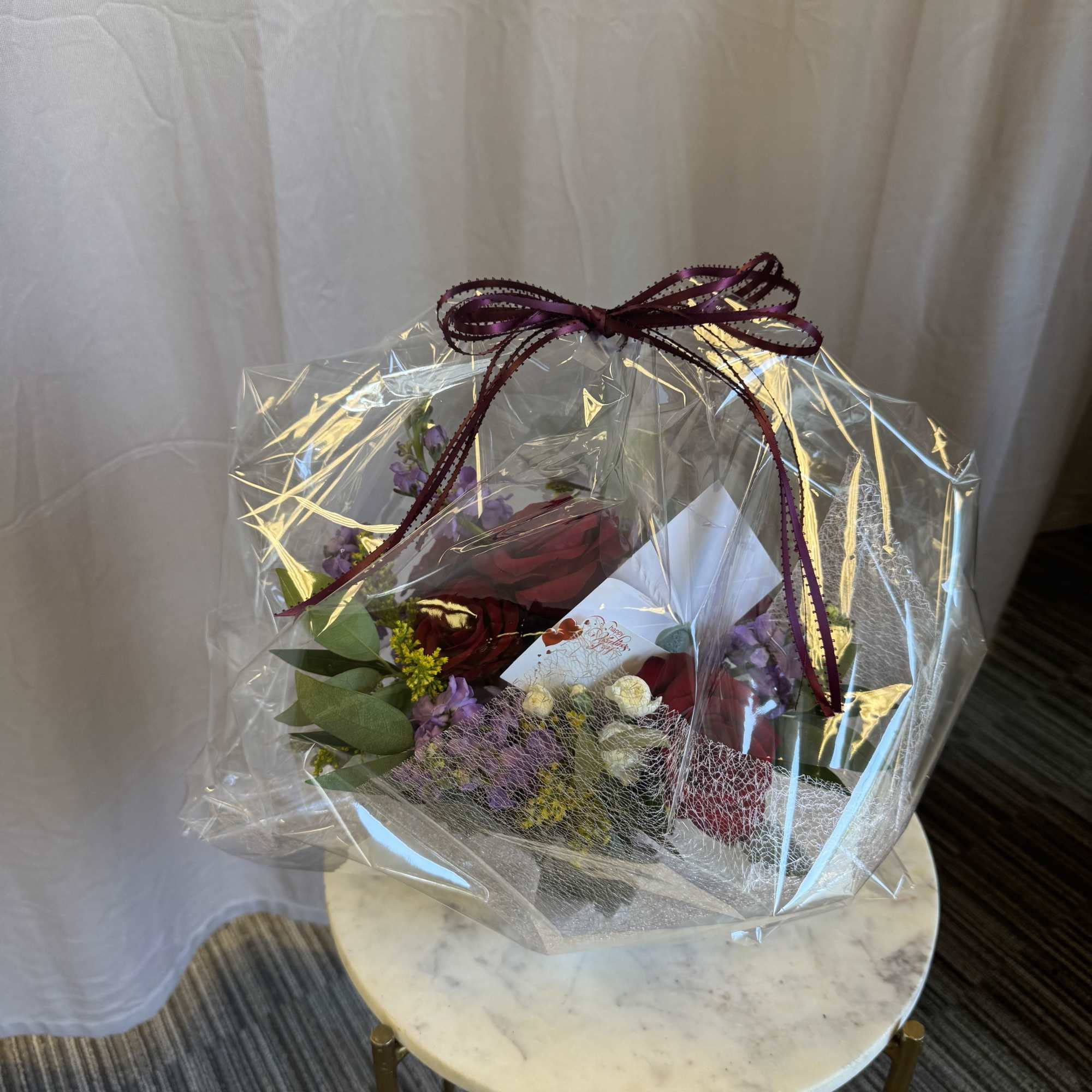 A soft yet striking floral design featuring rich red roses paired with