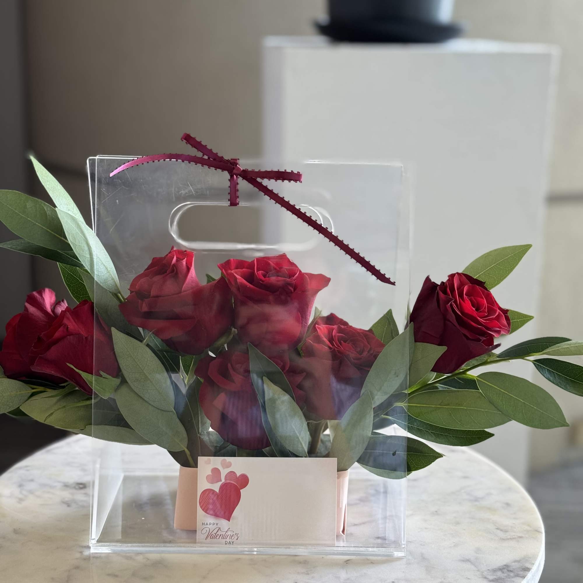 A charming and modern rose arrangement featuring fresh deep red roses nestled