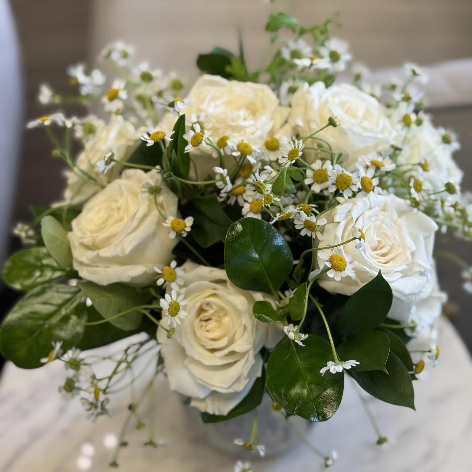 A fresh and elegant arrangement featuring creamy white premium roses accented with