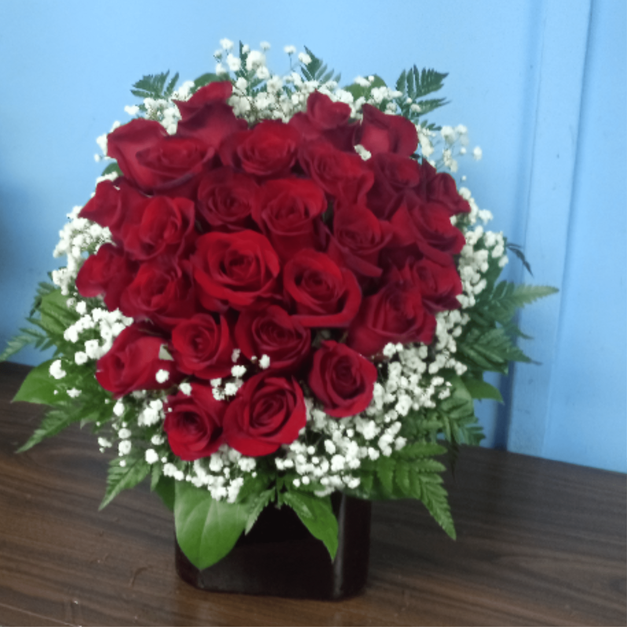 premium red roses artistically designed in a heart shape in a red