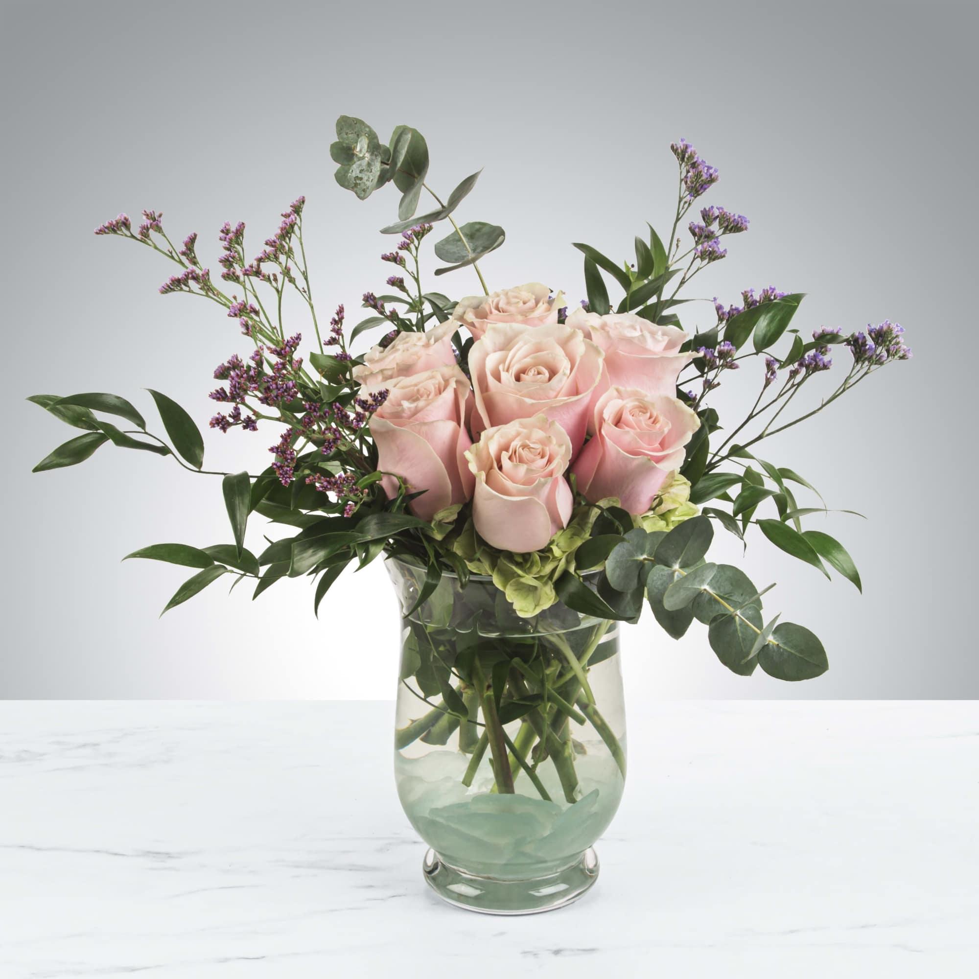 Blush roses with a variety of greenery and eucalyptus come together for