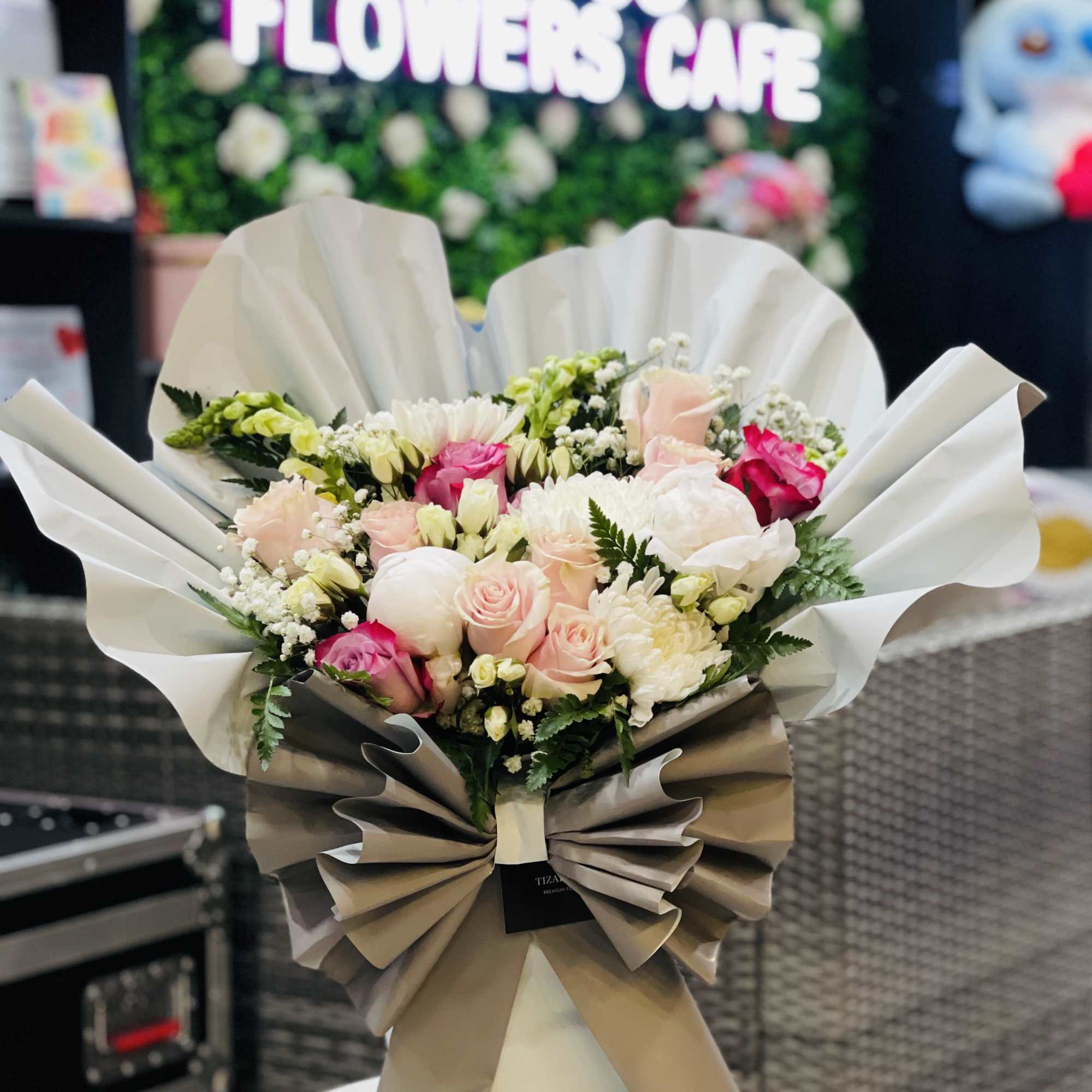 is a soft, romantic arrangement crafted with premium blush roses, white spray