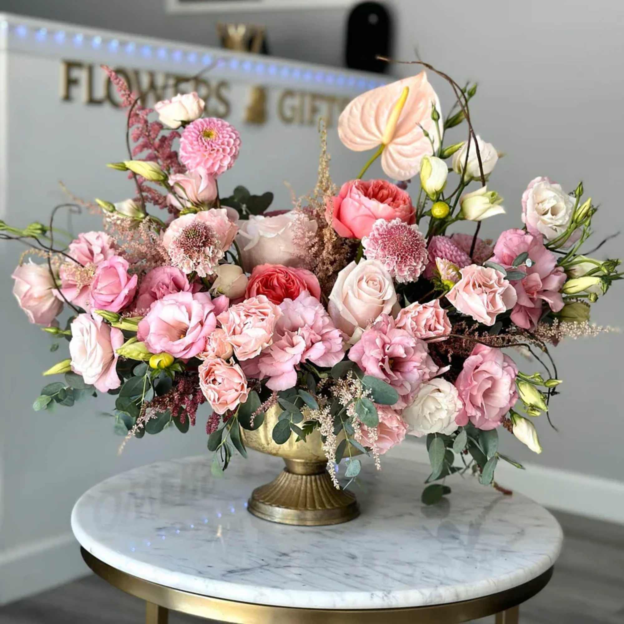 The Modern Elegance Arrangement in a gold vase is a stunning display