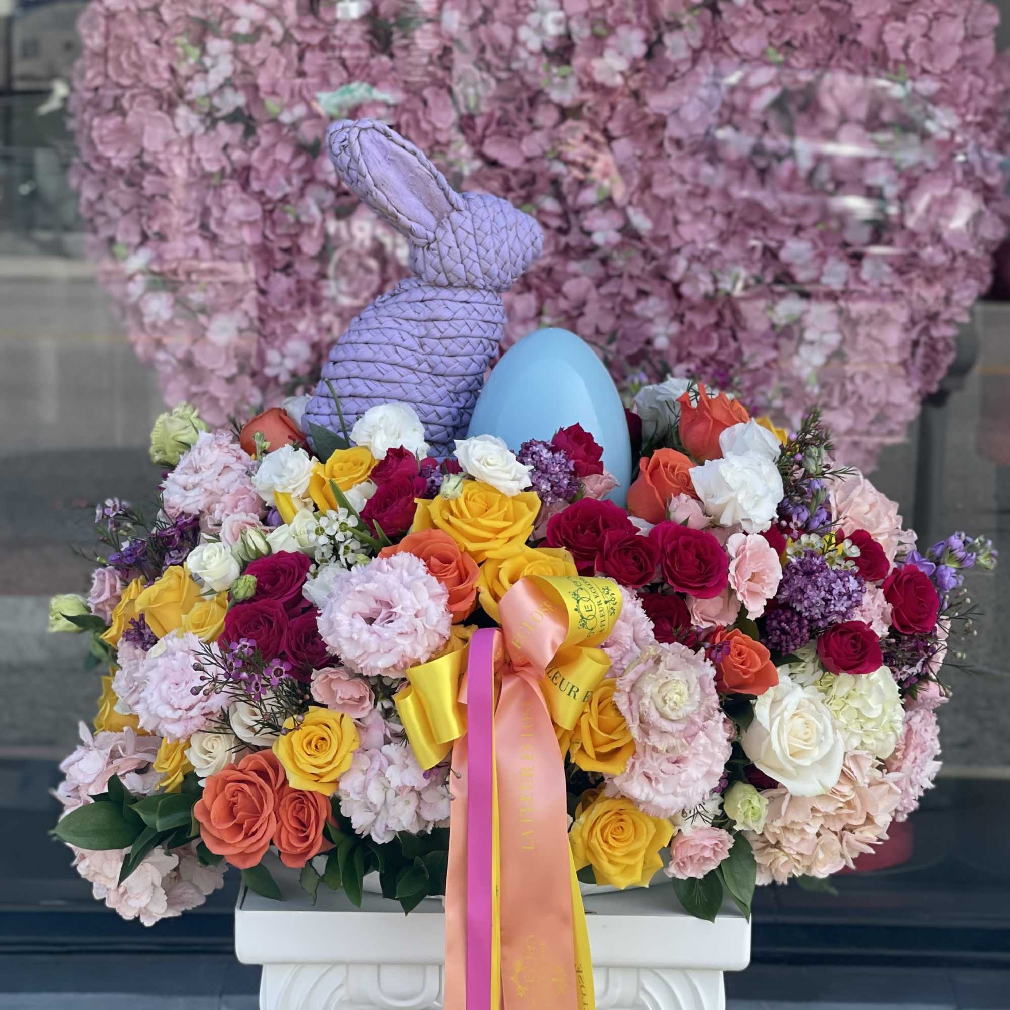 Mix of beautiful, fresh flowers in a vase with Easter decorations on