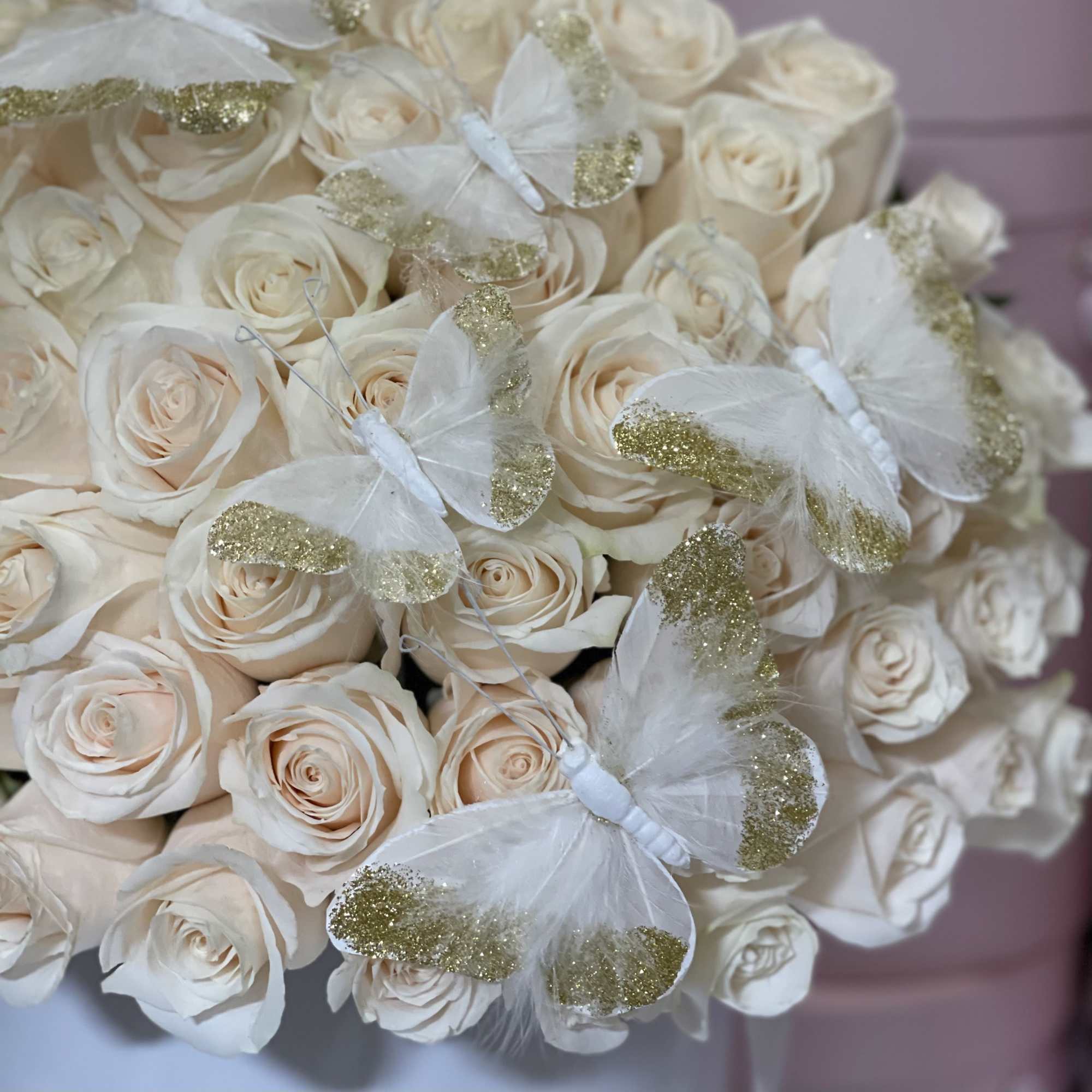 Standard 50 white roses in our signature pink box with butterflies 
Deluxe