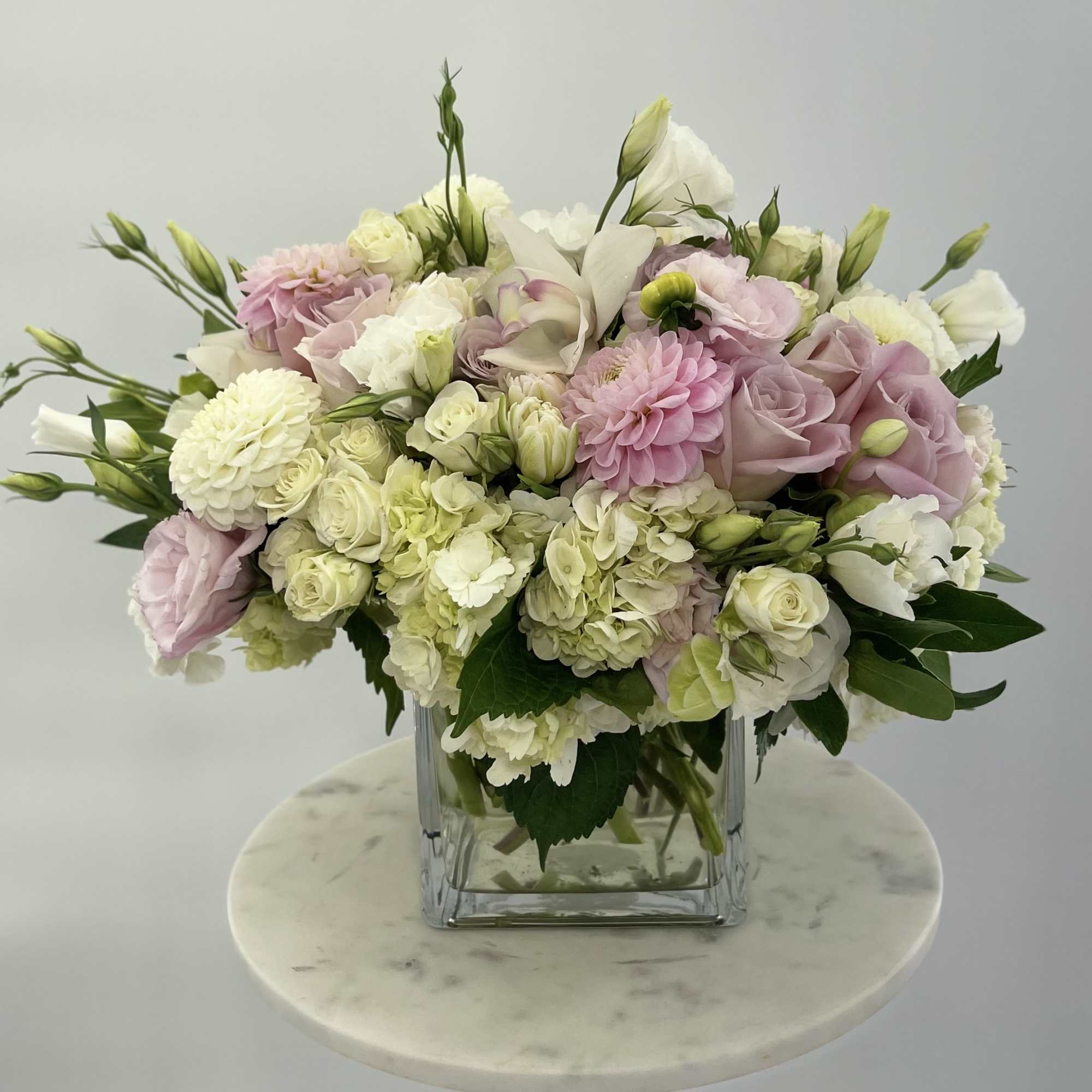 Pastel arrangement of the fresh flowers in a glass vase 