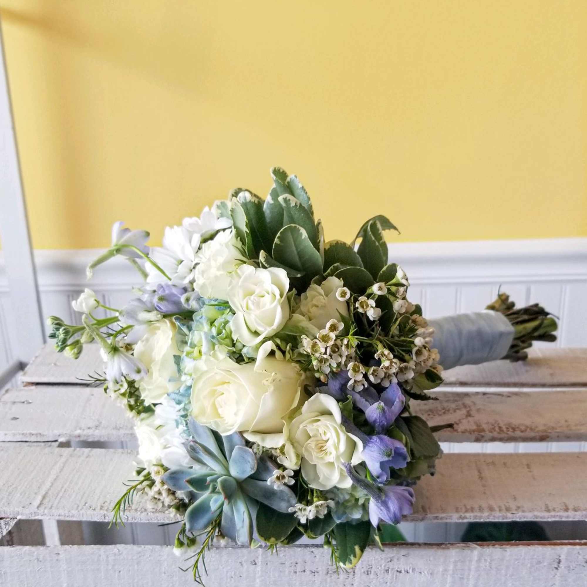 Handheld white and light blue prom bouquet with mixed flowers.
Actual Bouquets will