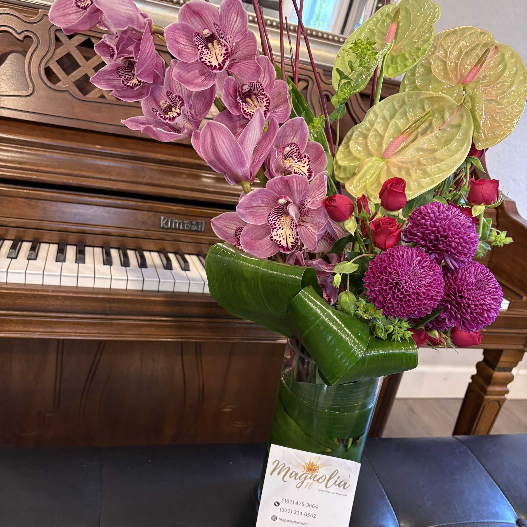 A striking assembly of vibrant petals and lush greenery, this floral arrangement