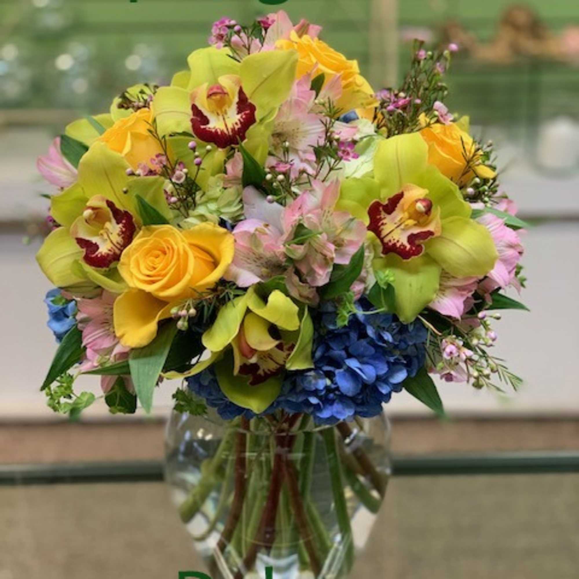 Arrangement filled with the best and brightest blossoms...Roses, hydrangea, orchids and more